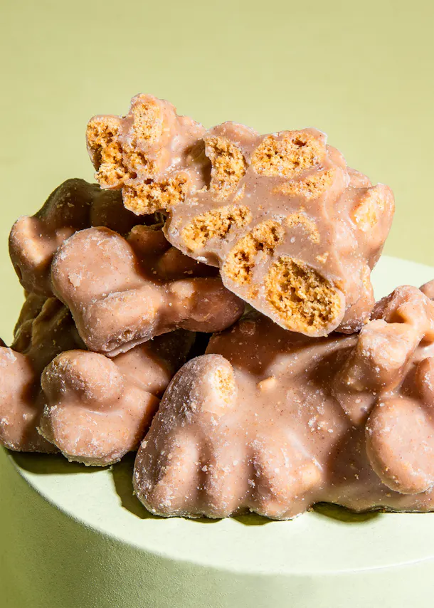 un tas de biscuits enrobés de chocolat sont posés sur une assiette verte