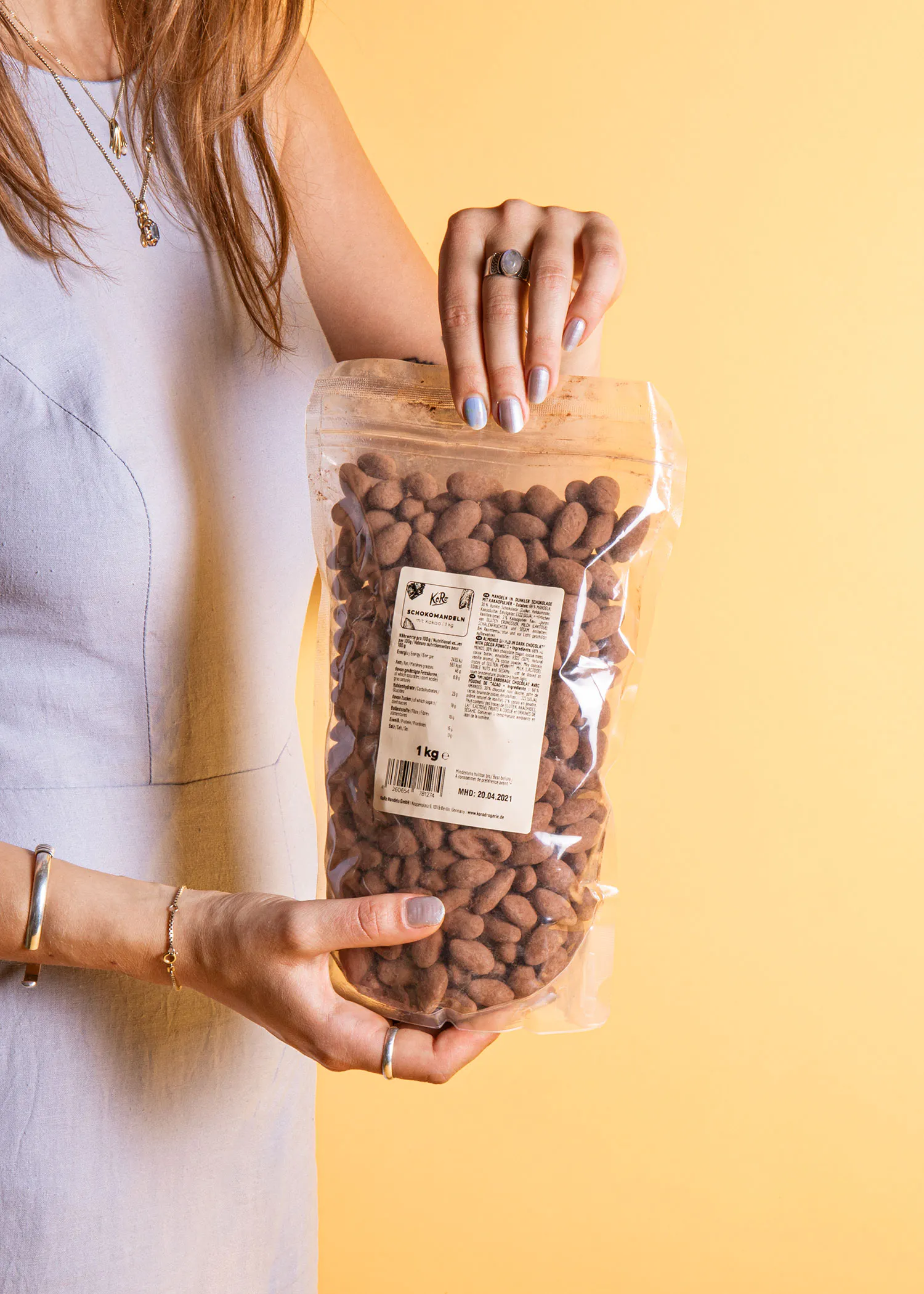 une femme tient un sac d' amandes au chocolat dans ses mains