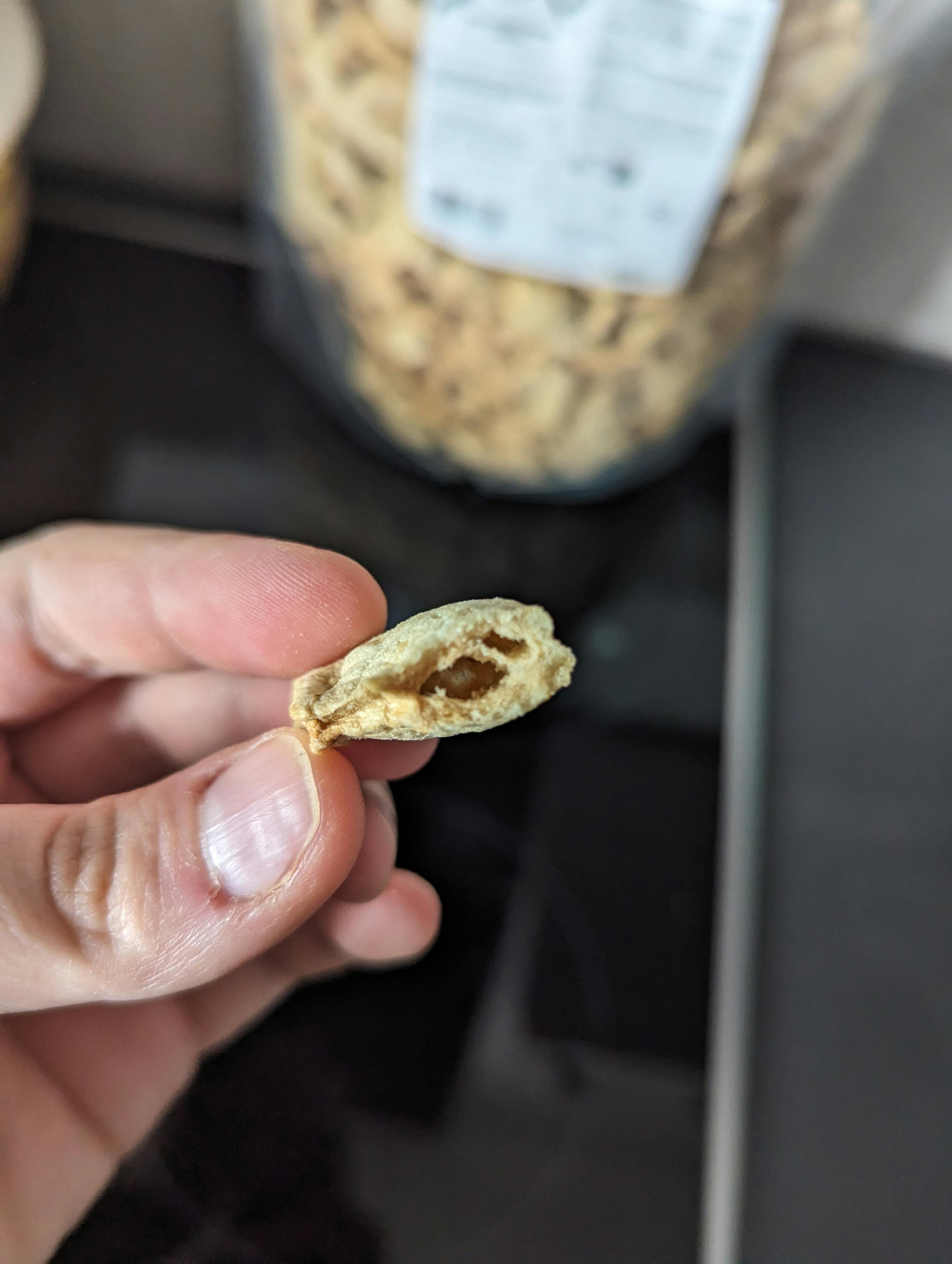 a person is holding a piece of cereal in their hand