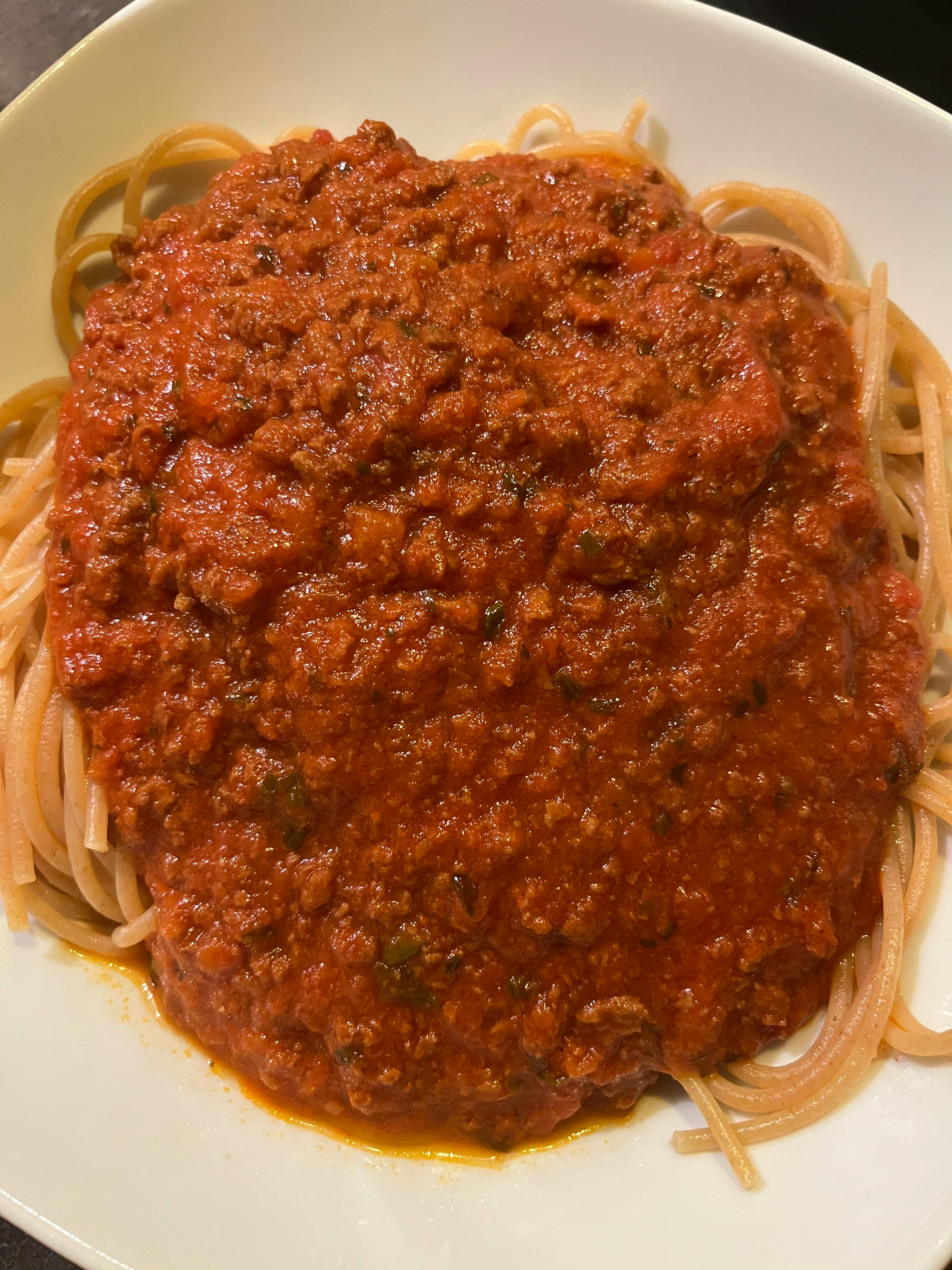 ein weißer Teller mit Spaghetti und Tomatensoße