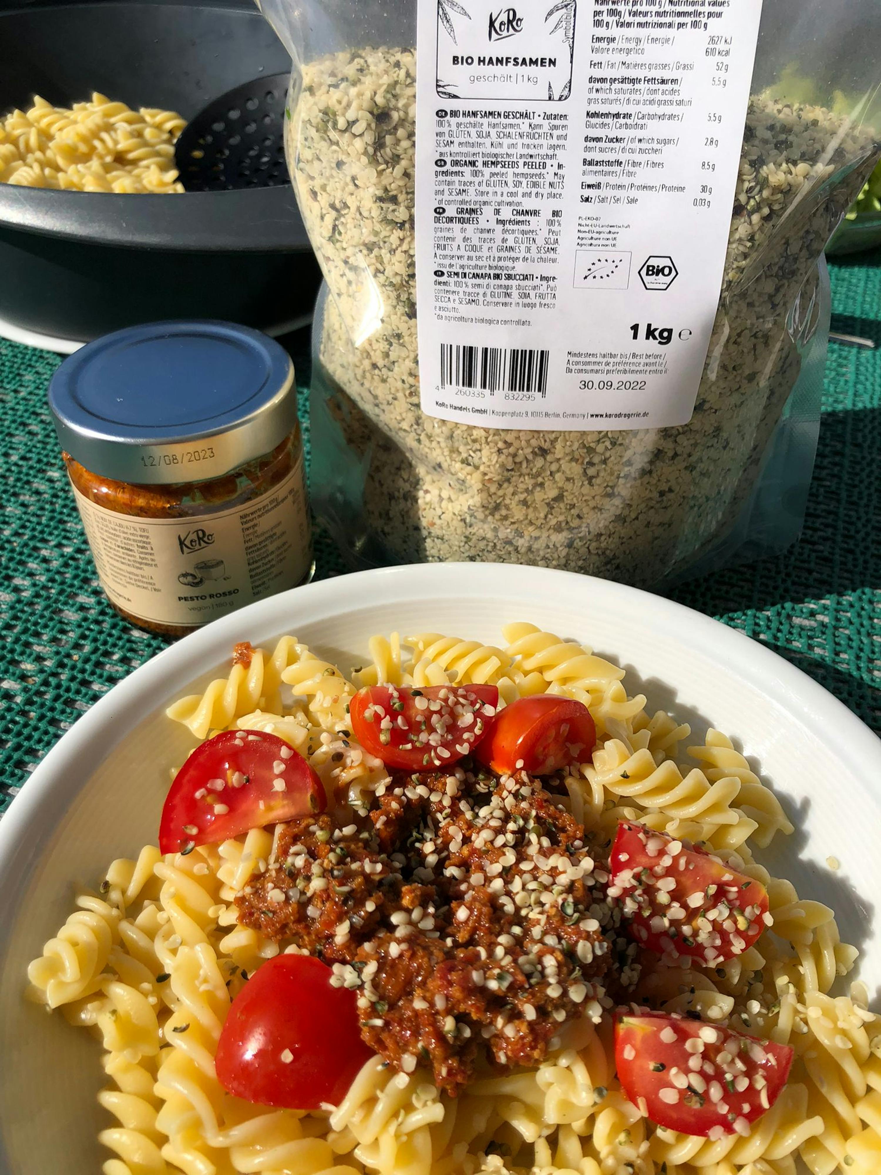 un piatto di pasta con pomodorini e un sacchetto di cibo in background