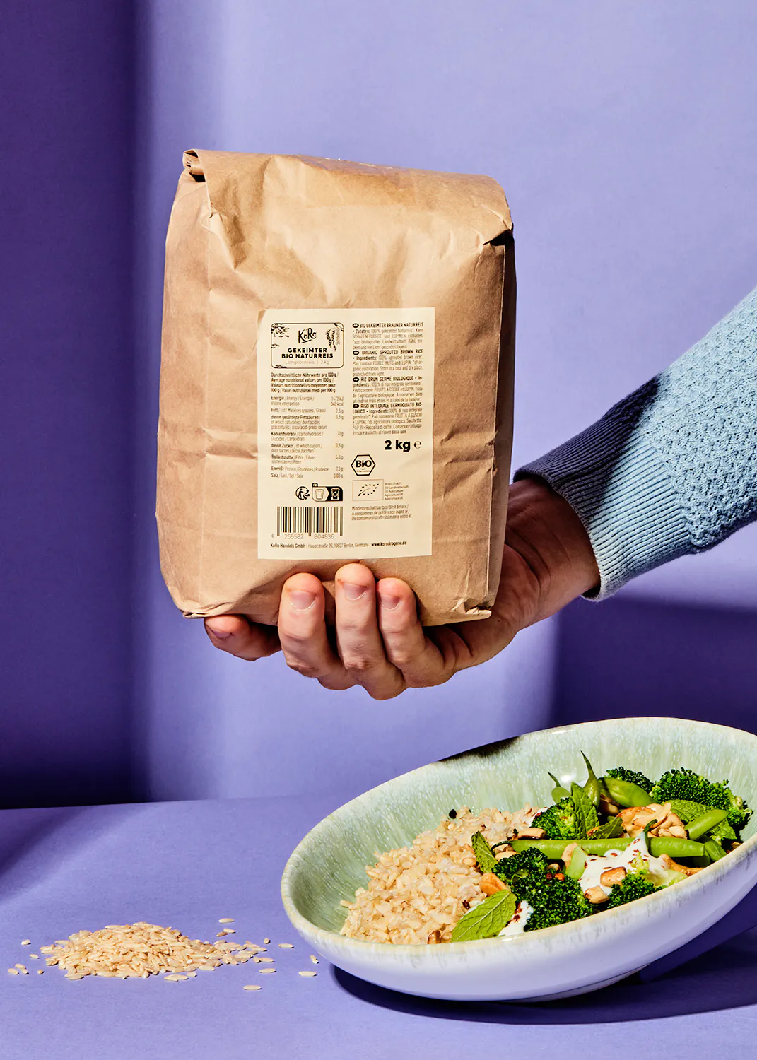 una persona tiene in mano un sacchetto di riso e un piatto di broccoli