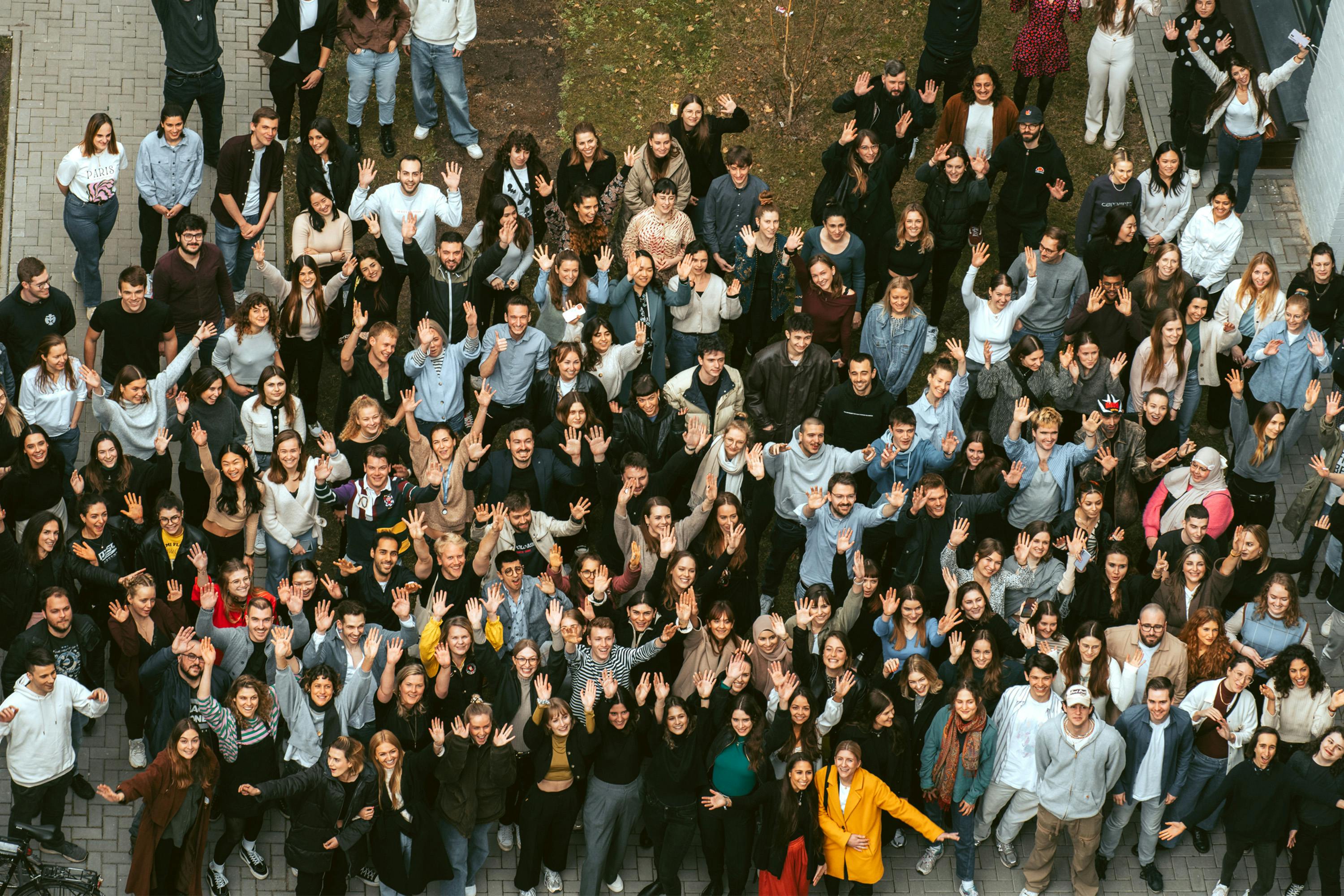 a large group of people waving their hands in the air