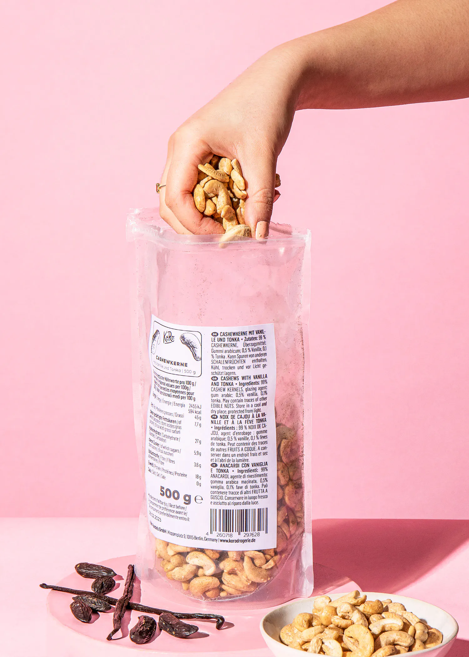 a person is holding a bag of cashews next to a bowl of cashews