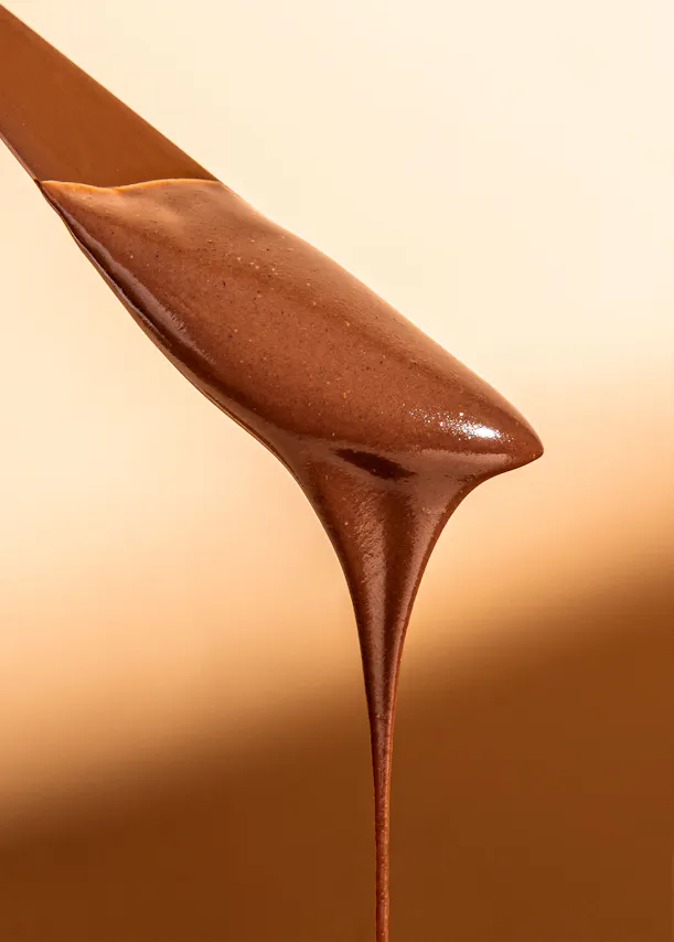 un gros plan d' une cuillère remplie de sauce au chocolat