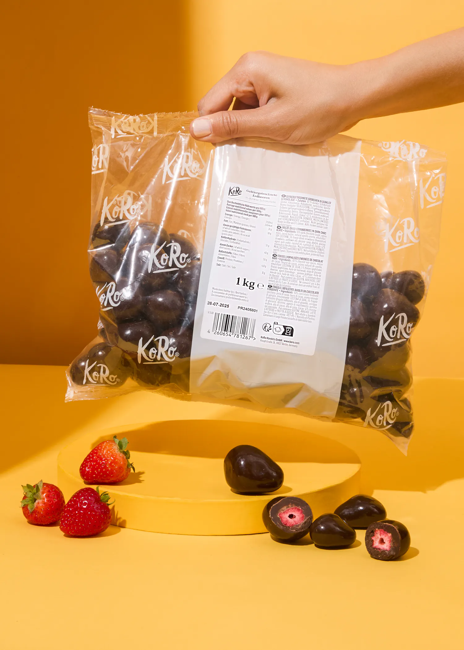 une personne tient un sac de chocolat enveloppé de fraises