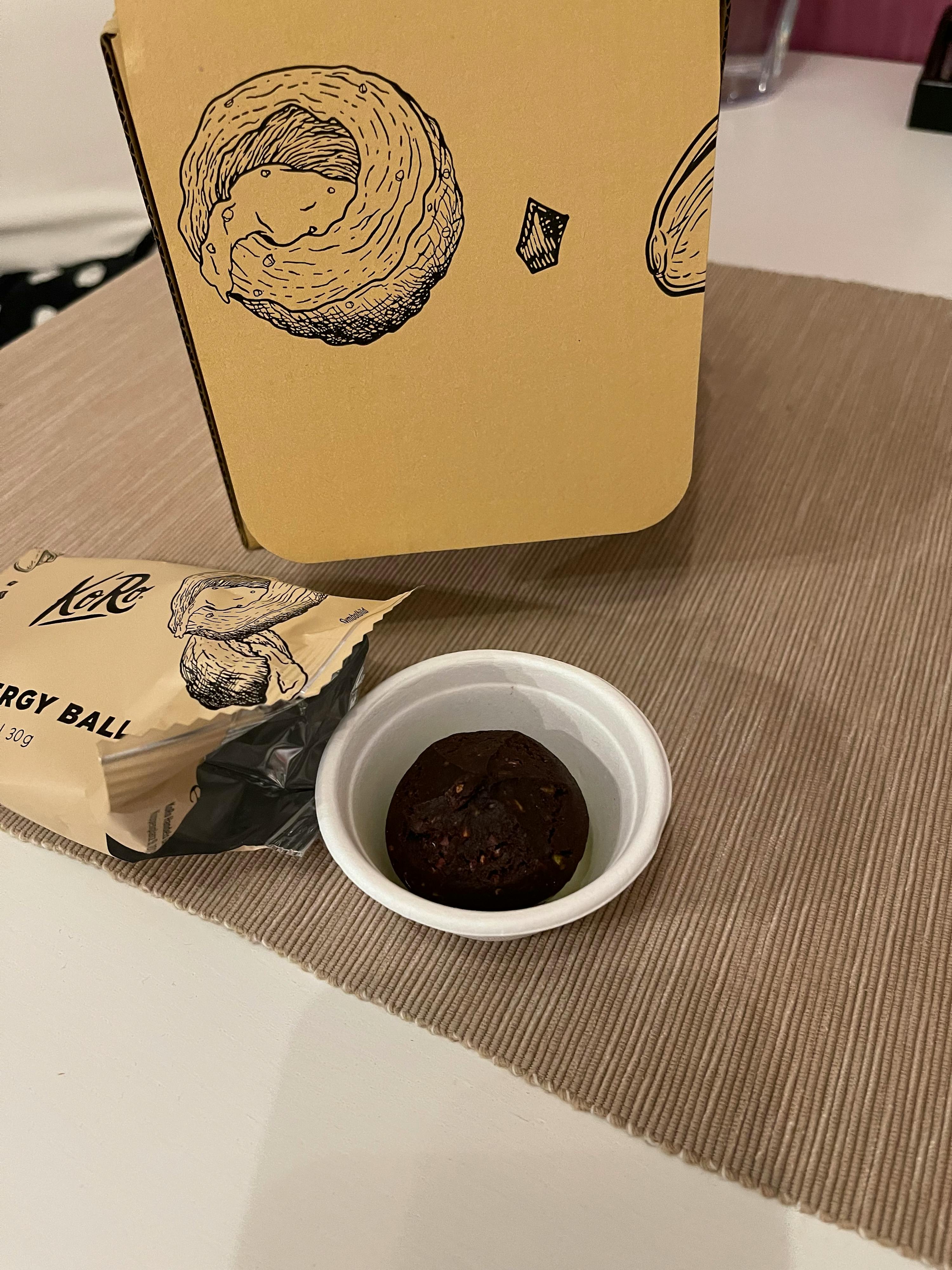 una palla di cioccolato è seduta su un tavolo accanto a una scatola di cartone