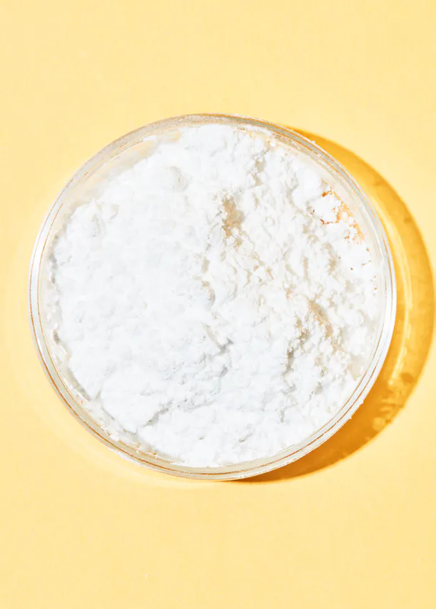 white powder in a plastic container on a yellow background