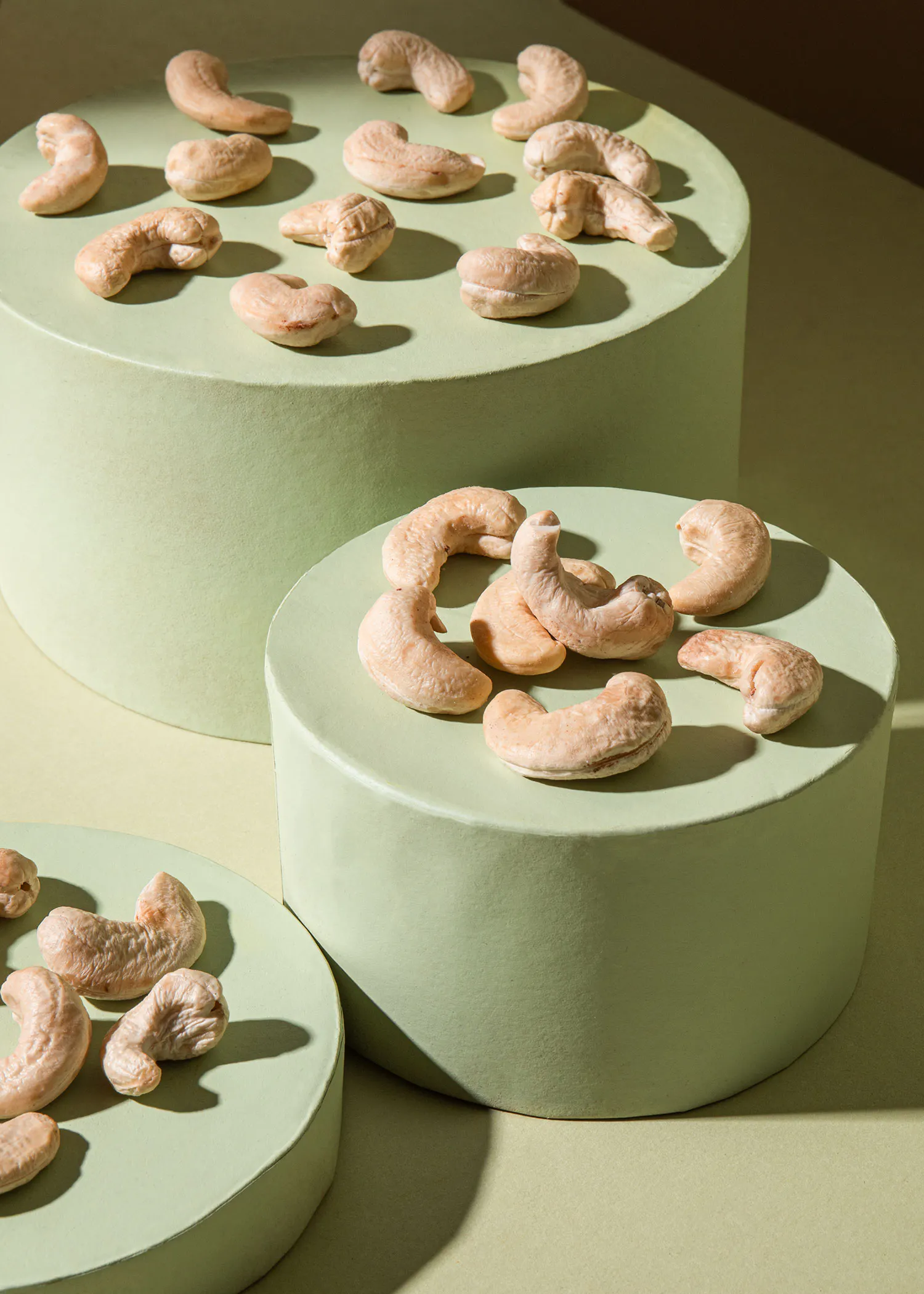 un tas de noix de cajou sont assis sur des plaques vertes