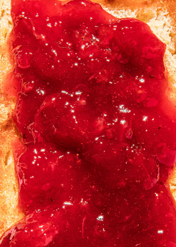 une tranche de pain avec de la confiture de framboise sur elle