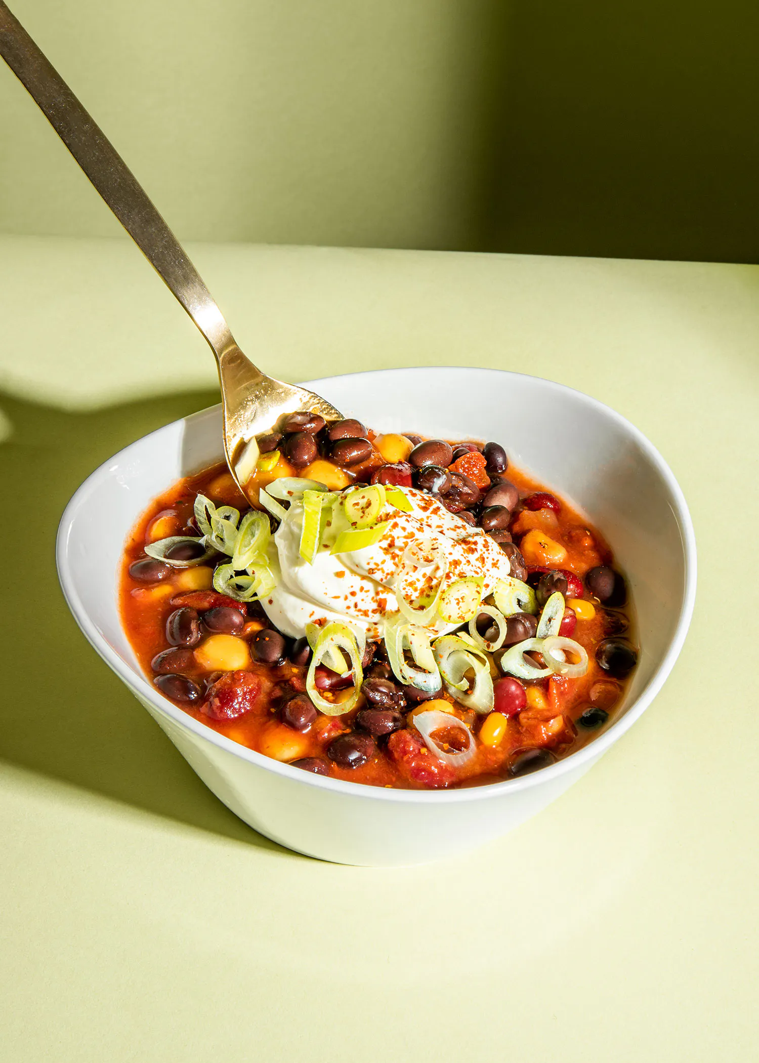 a bowl of chili with sour cream on top
