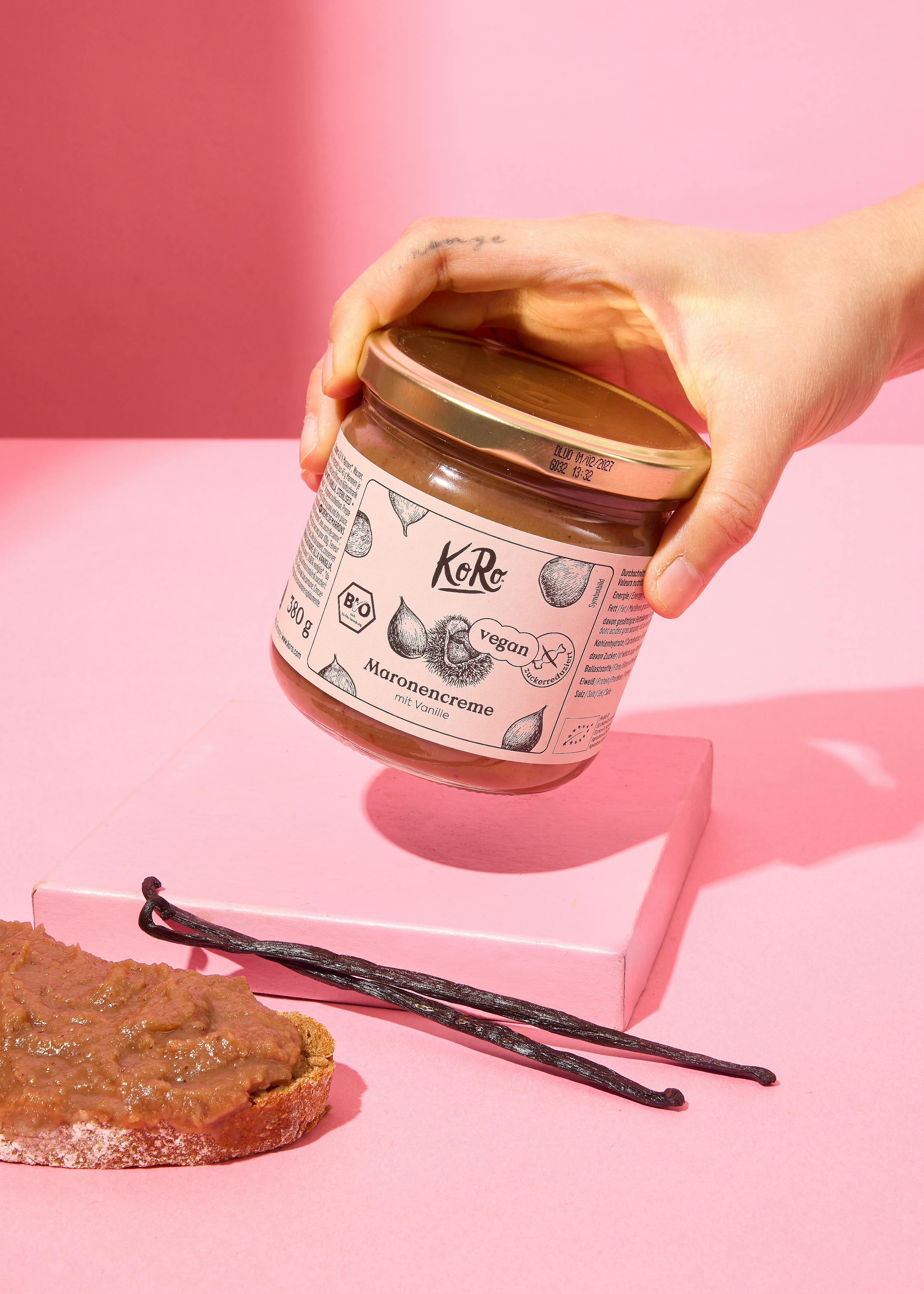 Eine Person hält ein Glas maronencreme in der Hand