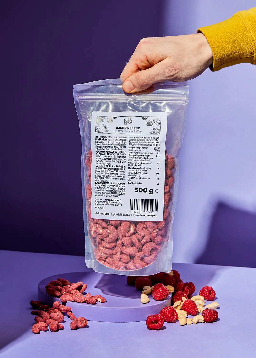 a person is holding a bag of cashew nuts