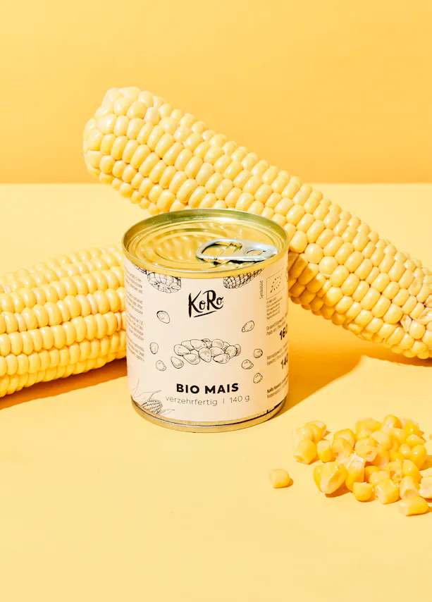 une boîte de maïs bio est assise à côté d' une épi de maïs
