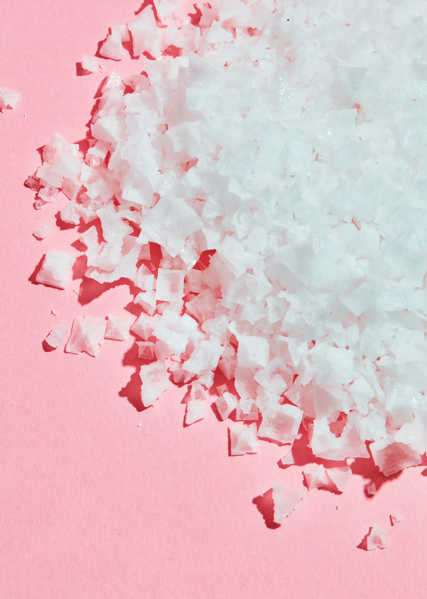 un tas de cristaux blancs sur un fond rose