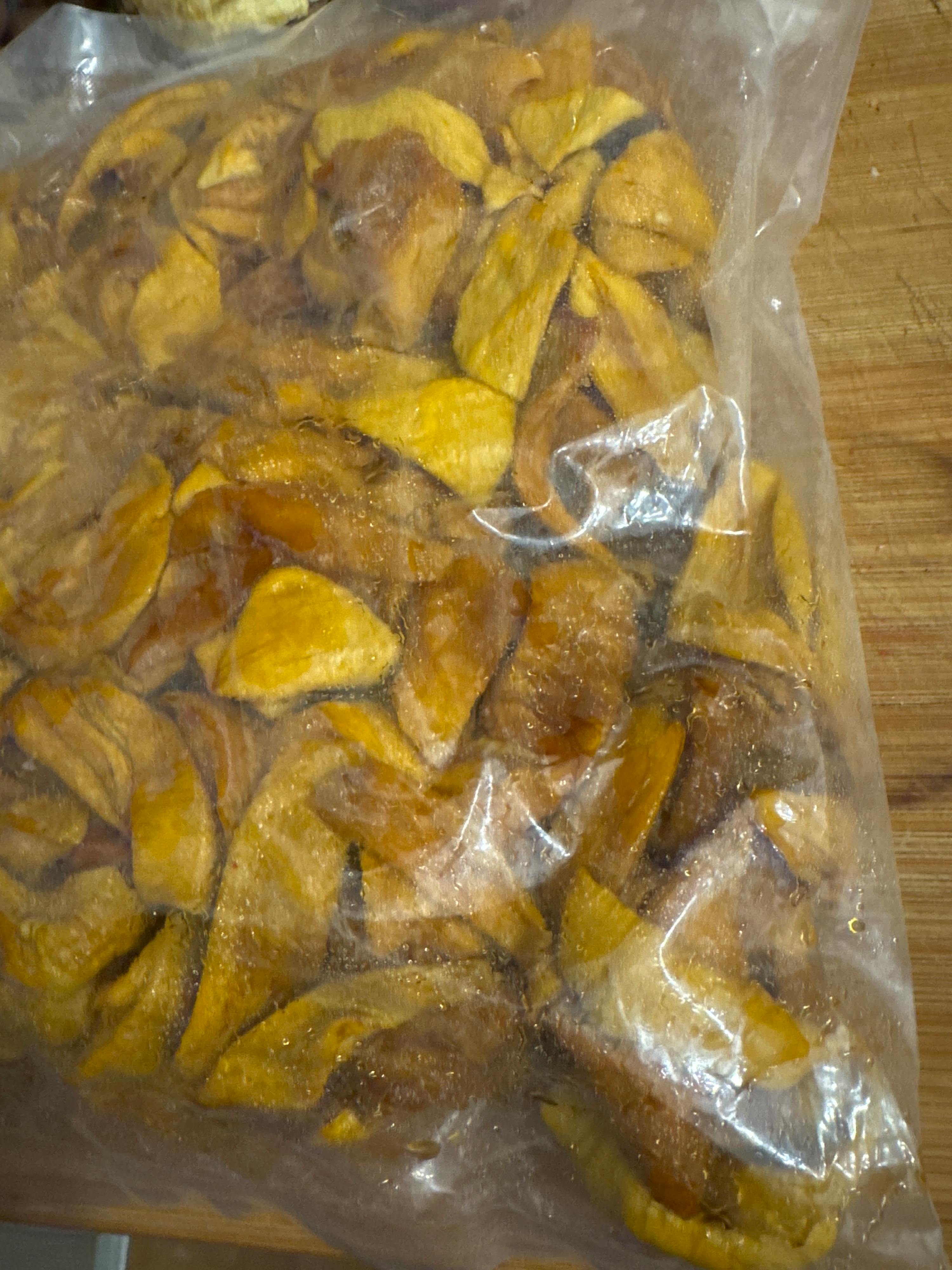 getrocknete mangostücke in einer durchsichtigen plastiktüte.