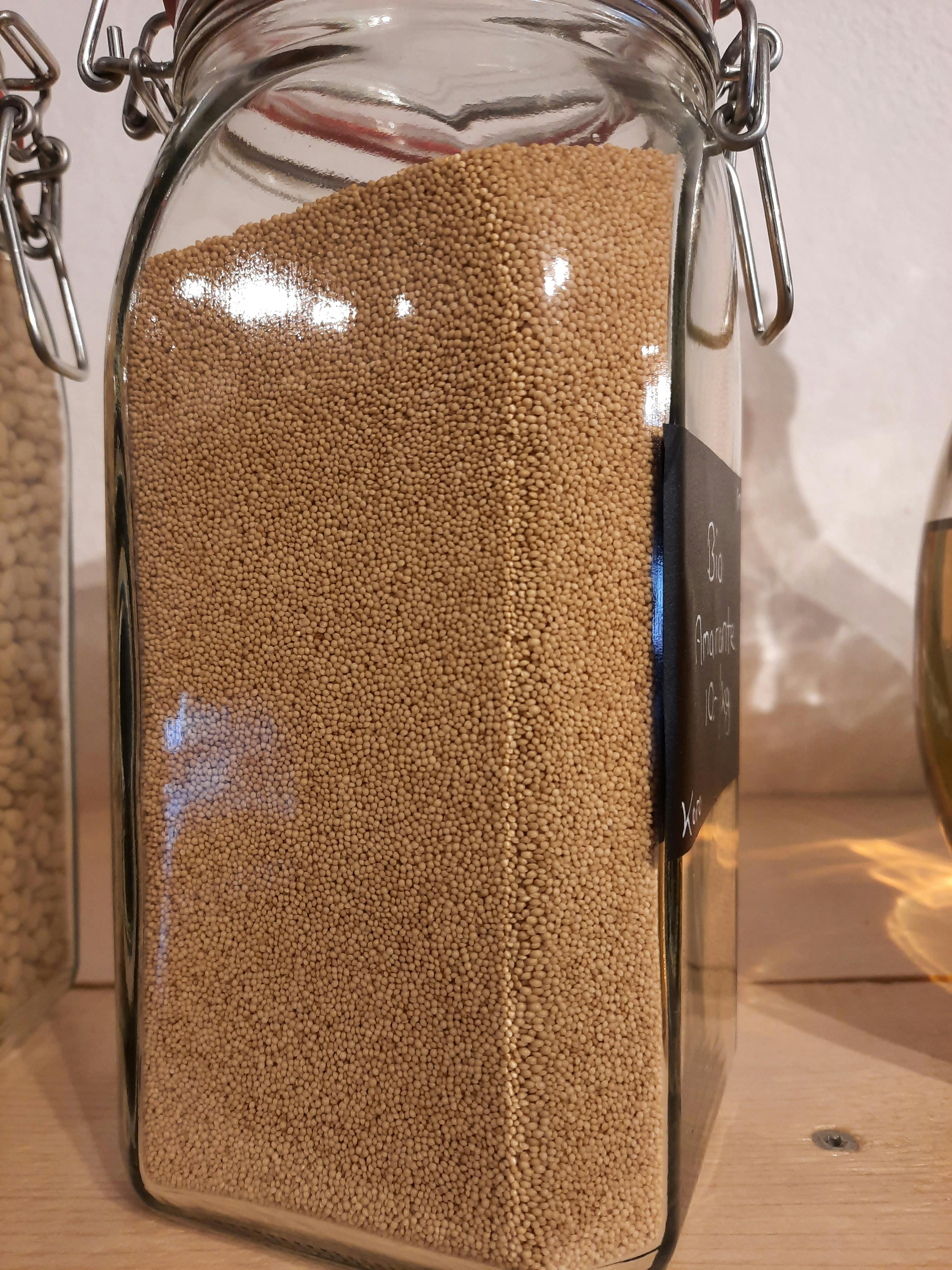 ein Glasgefäß gefüllt mit braunen Perlen mit einem schwarzen Etikett darauf