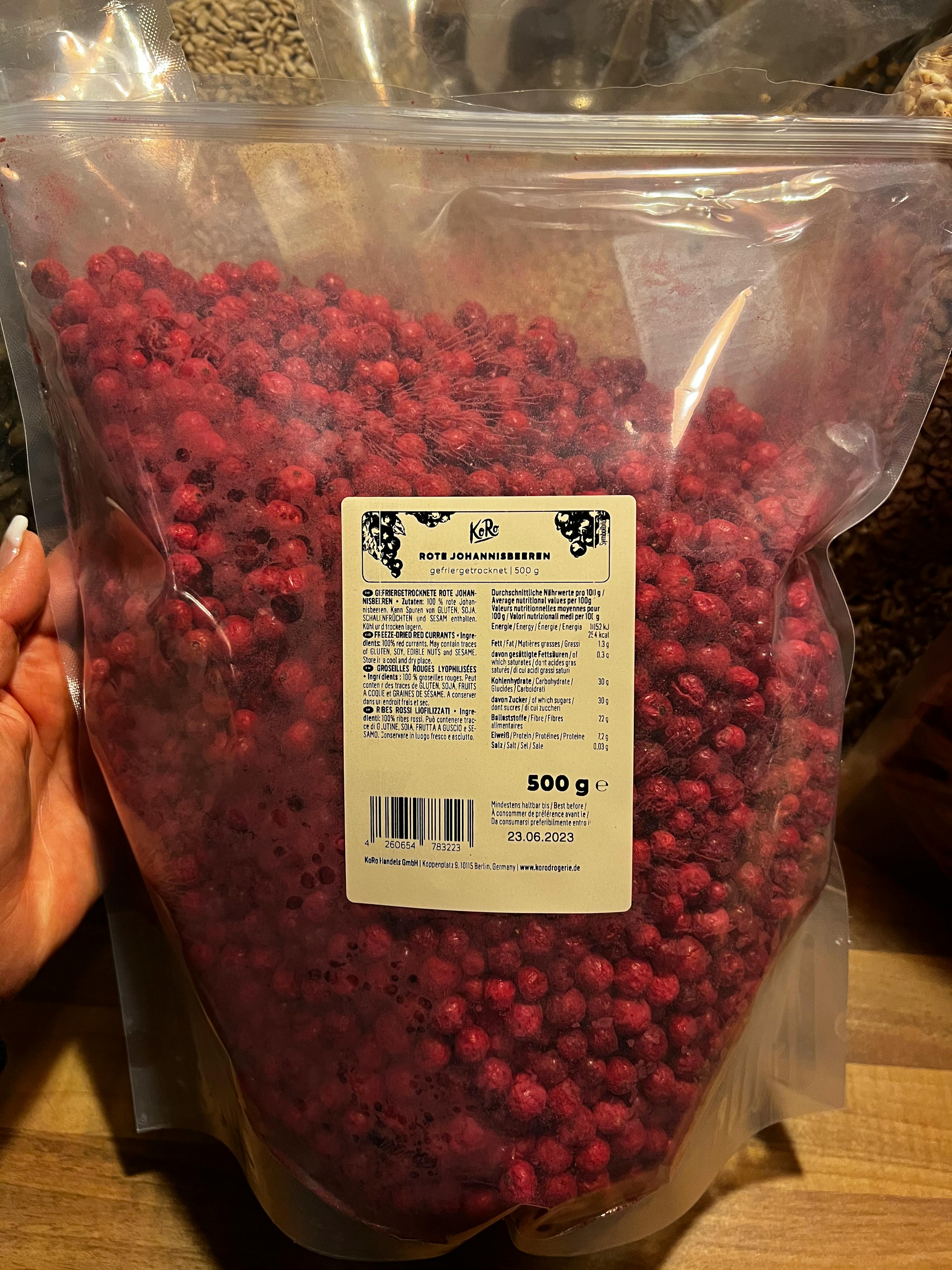 a person is holding a bag of frozen cranberries