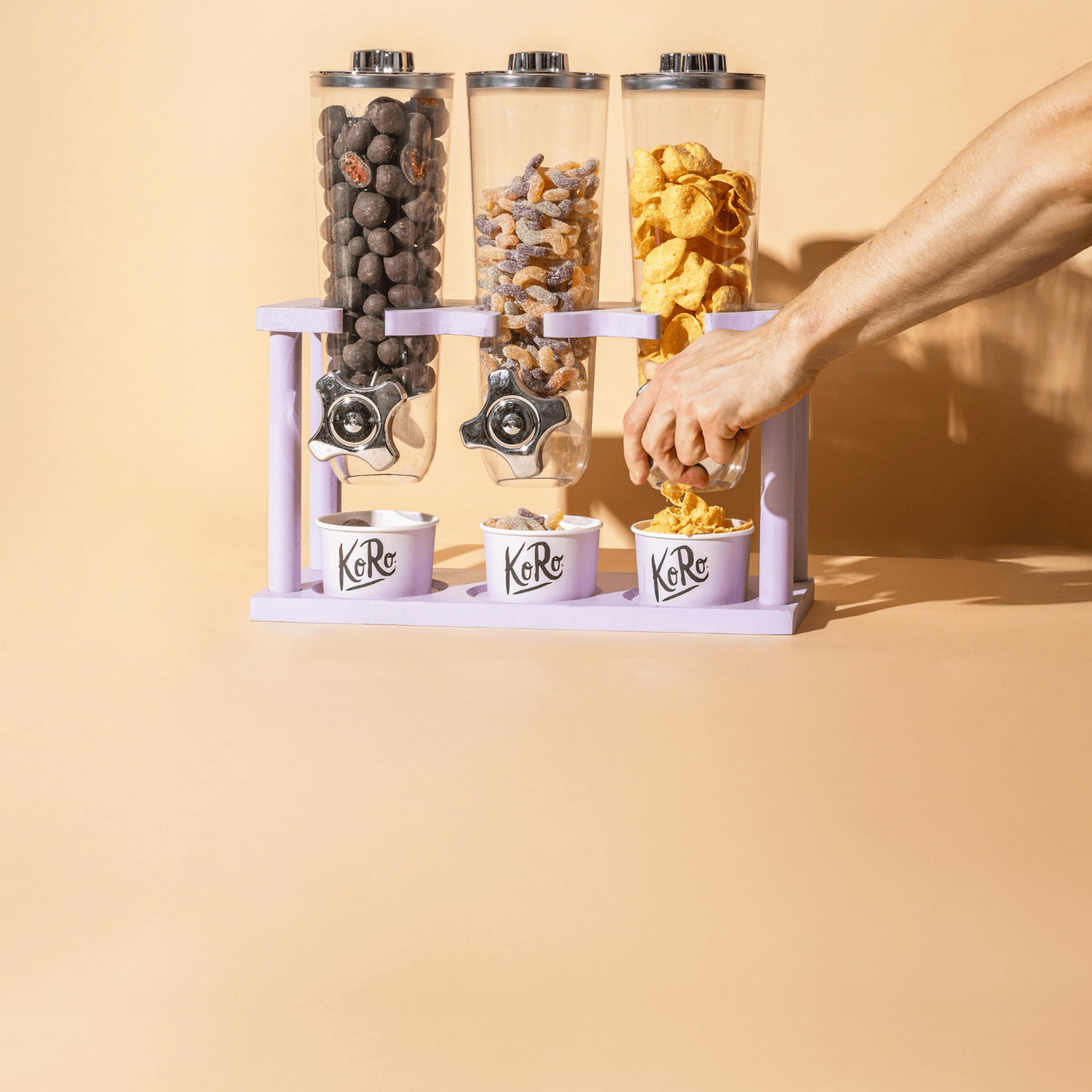 a person is pouring cereal into a purple kero dispenser