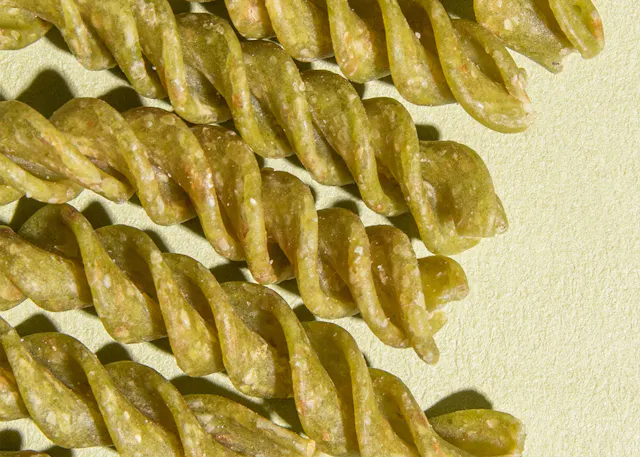 a close up of some green pasta on a green background