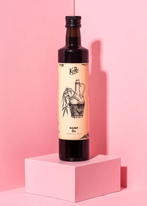 a bottle of hanf oil is sitting on a pink cube