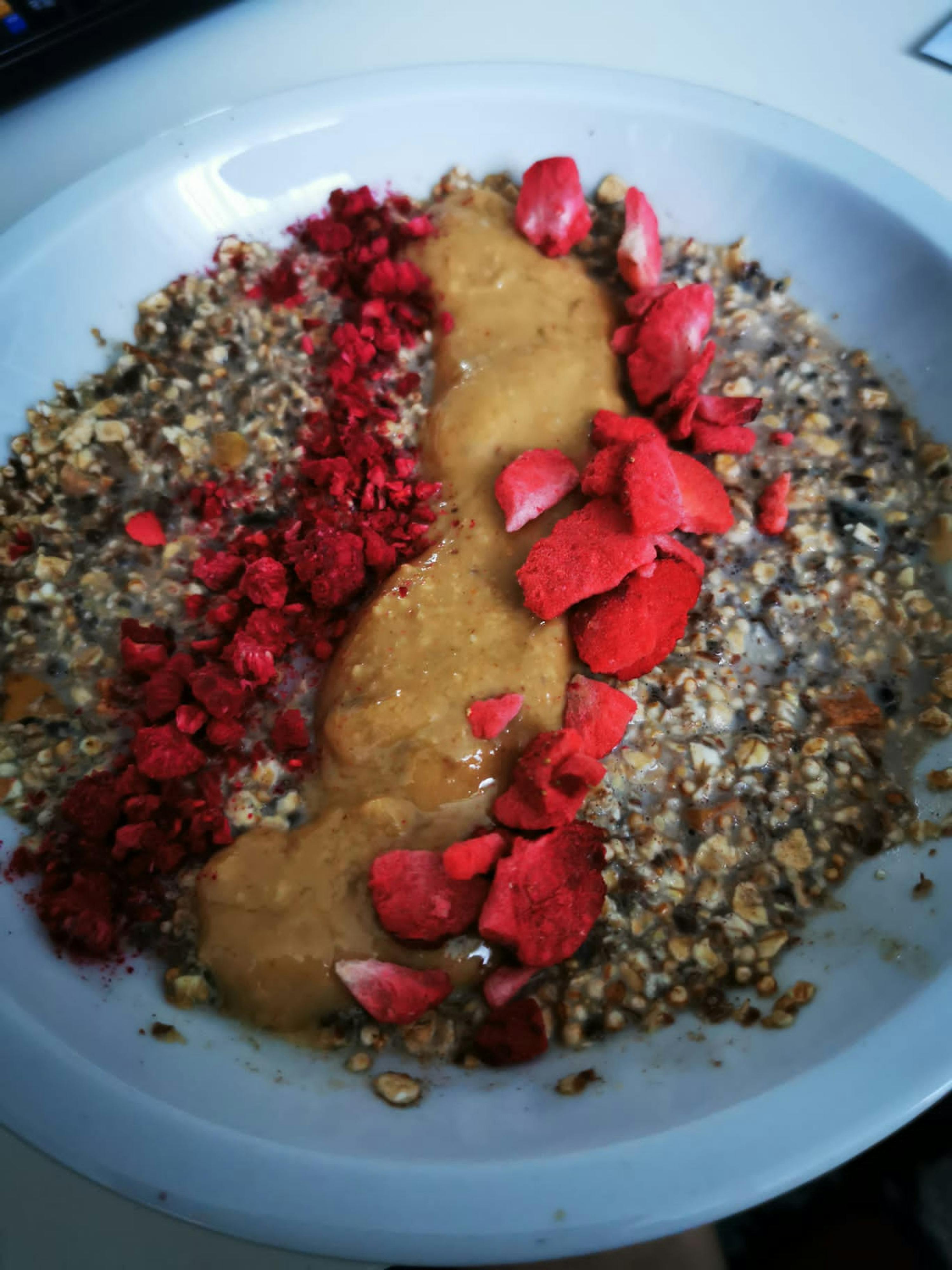 a bowl of oatmeal with peanut butter and raspberries