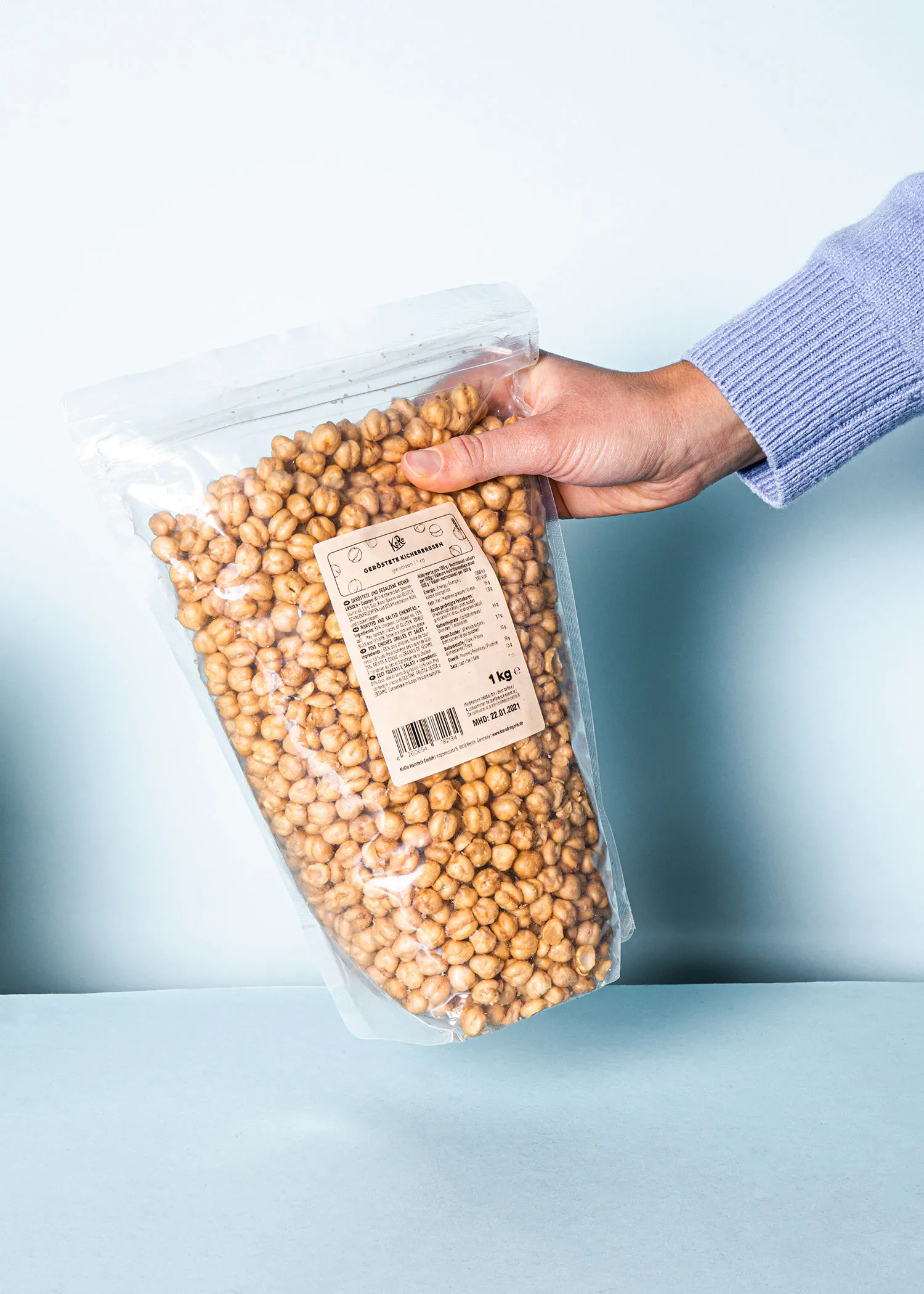 a person holding a bag of roasted chickpeas
