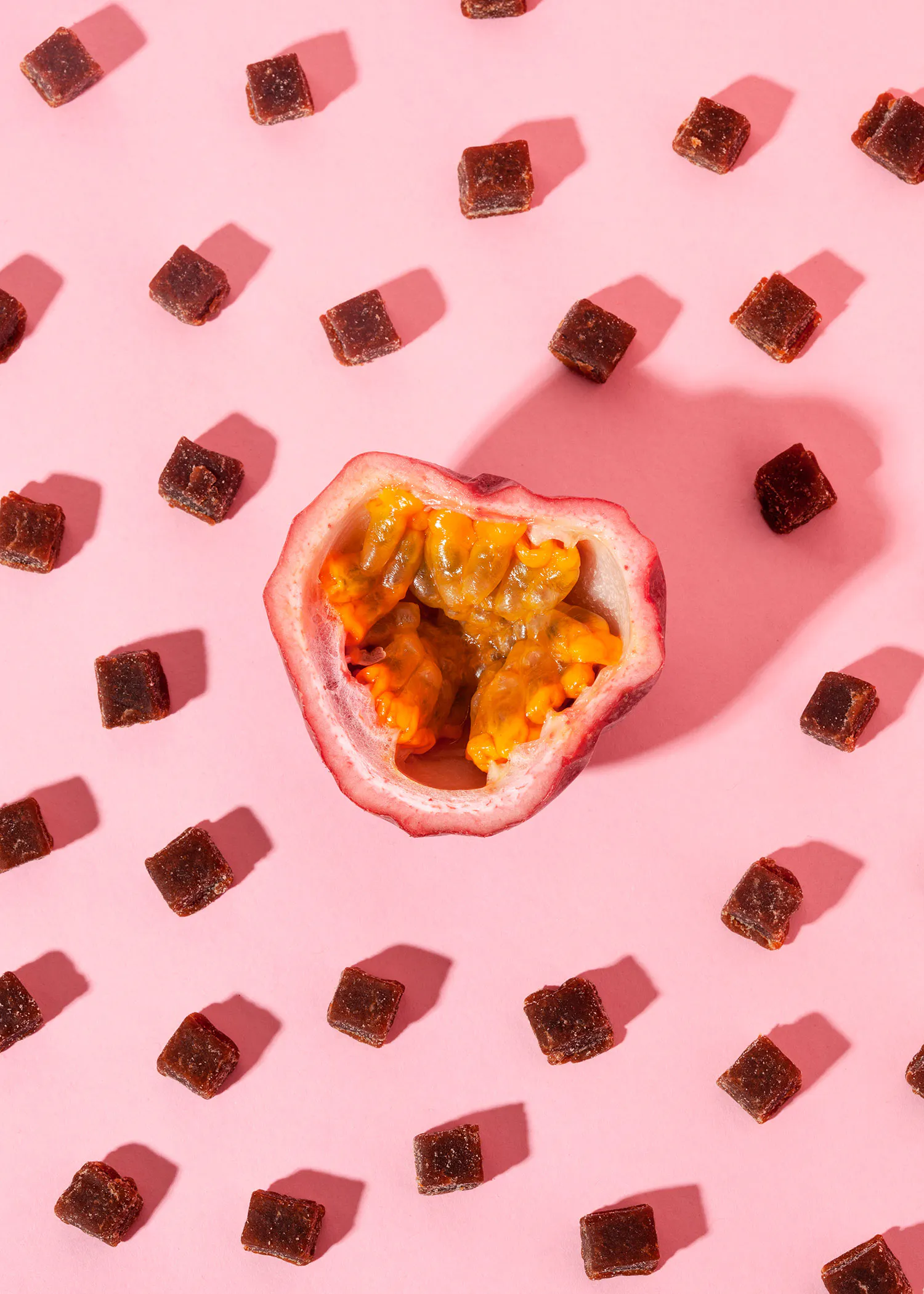 a slice of passion fruit is surrounded by small squares on a pink background