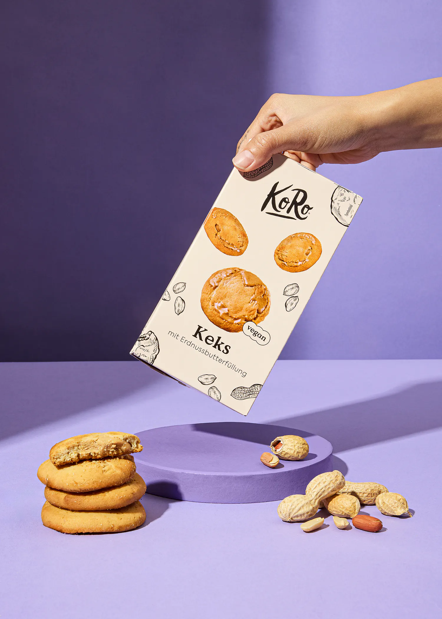 une personne tient une boîte de biscuits avec des cacahuètes