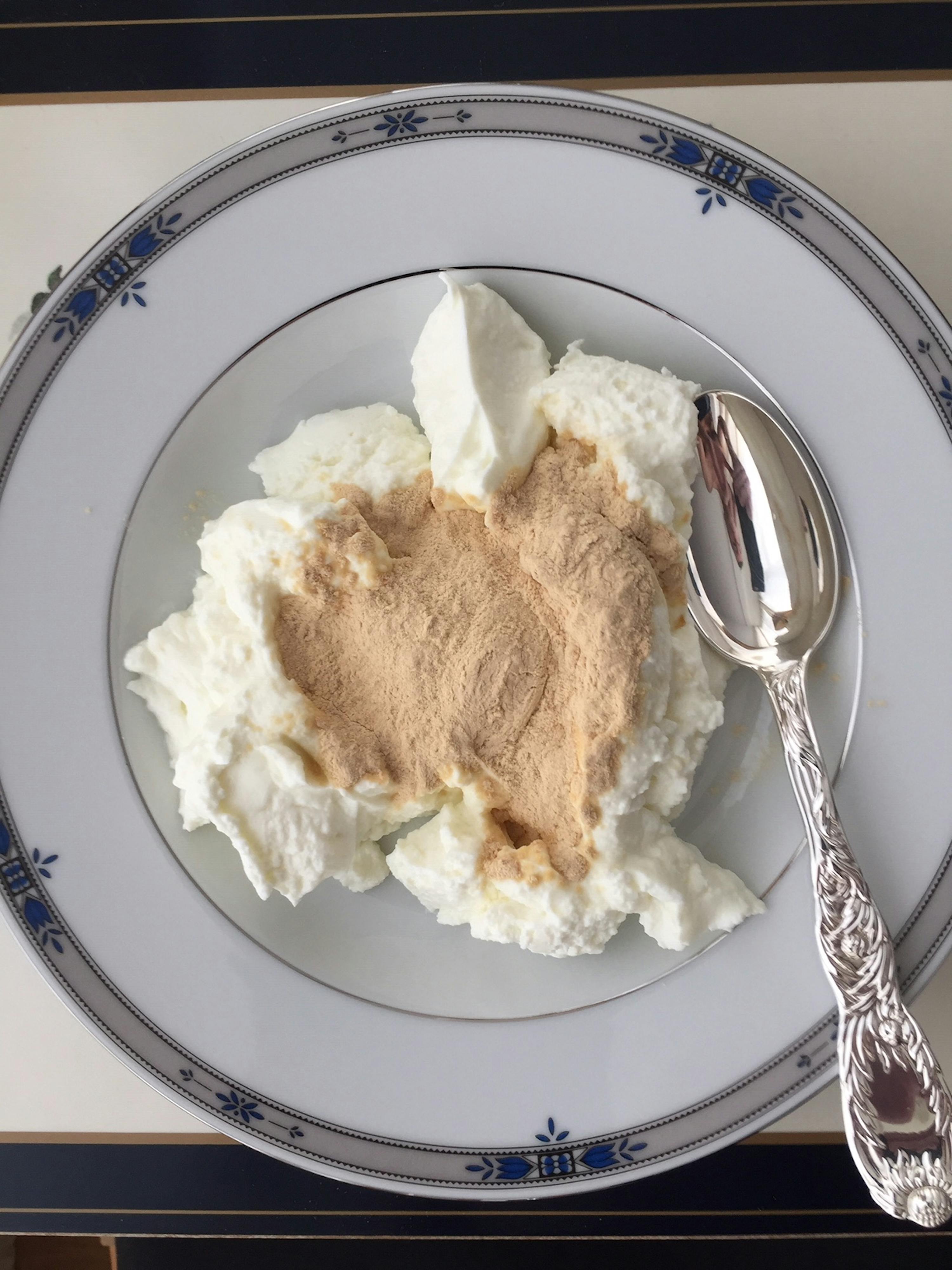 a plate of yogurt with a spoon on top of it