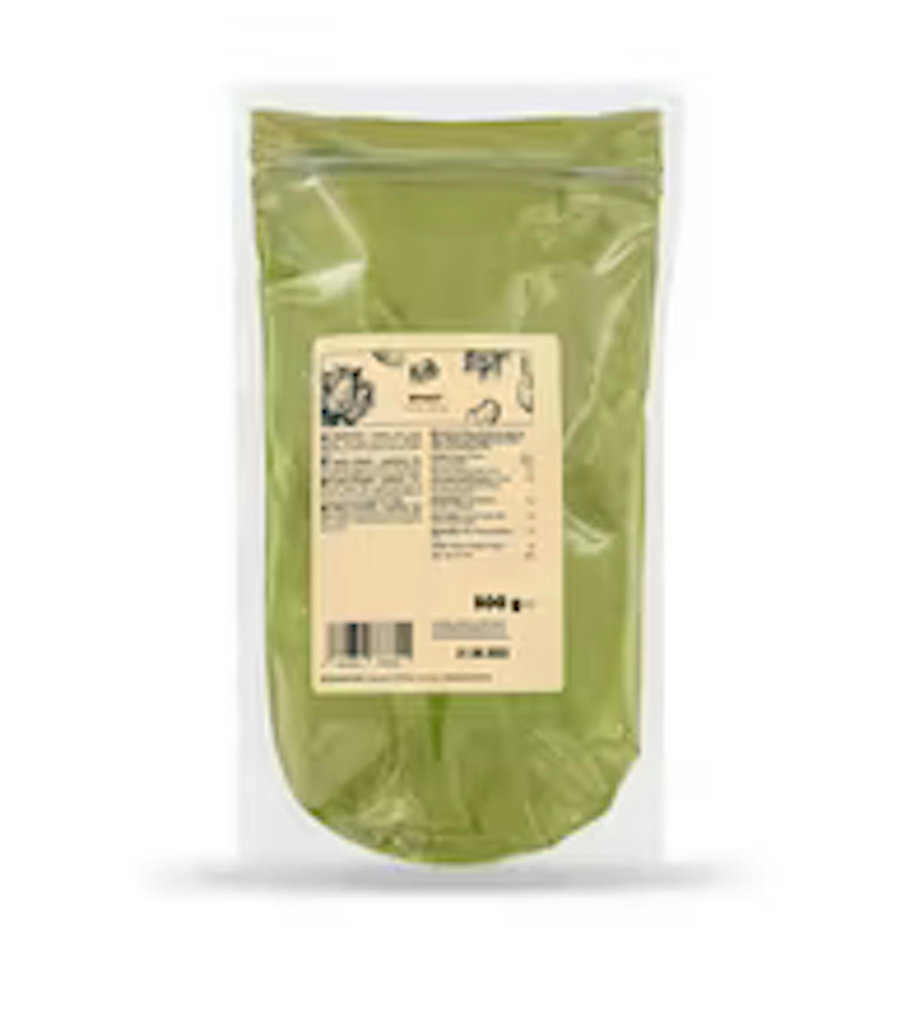 a bag of green powder with a label on it on a white background .