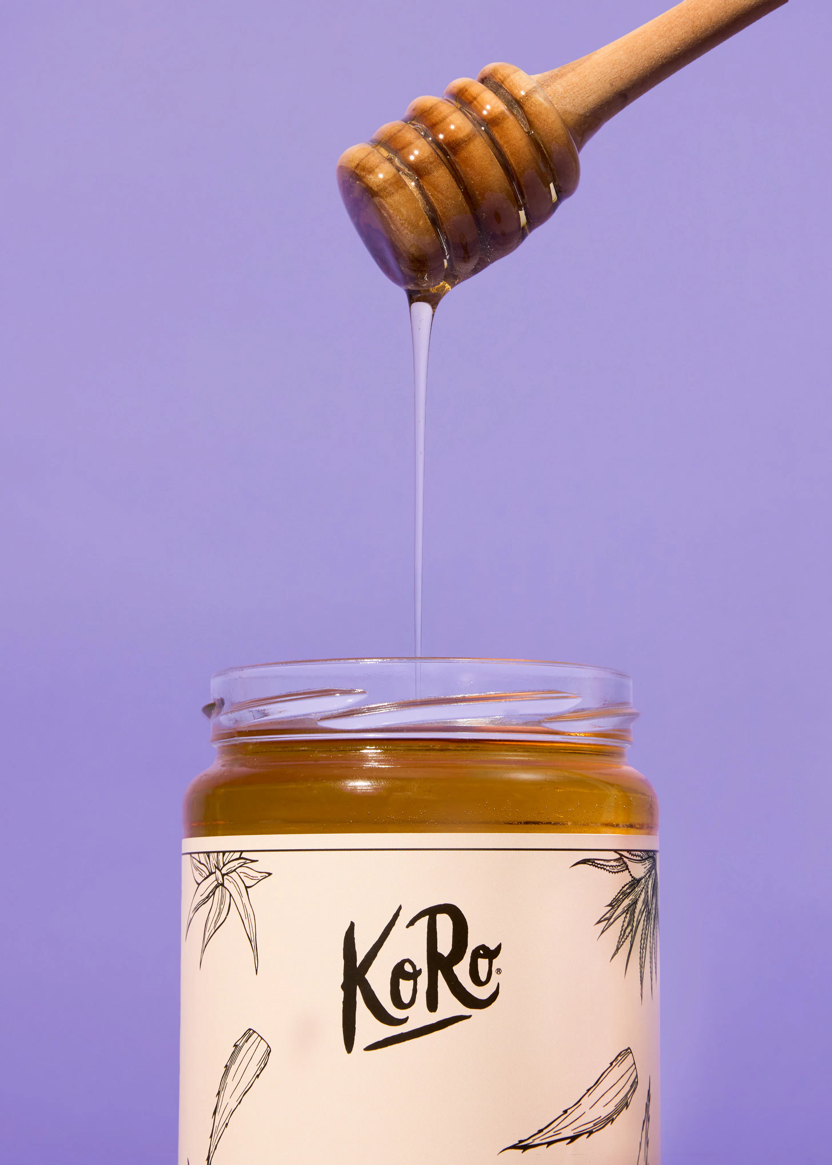 a jar of koro honey with a dipper sticking out of it