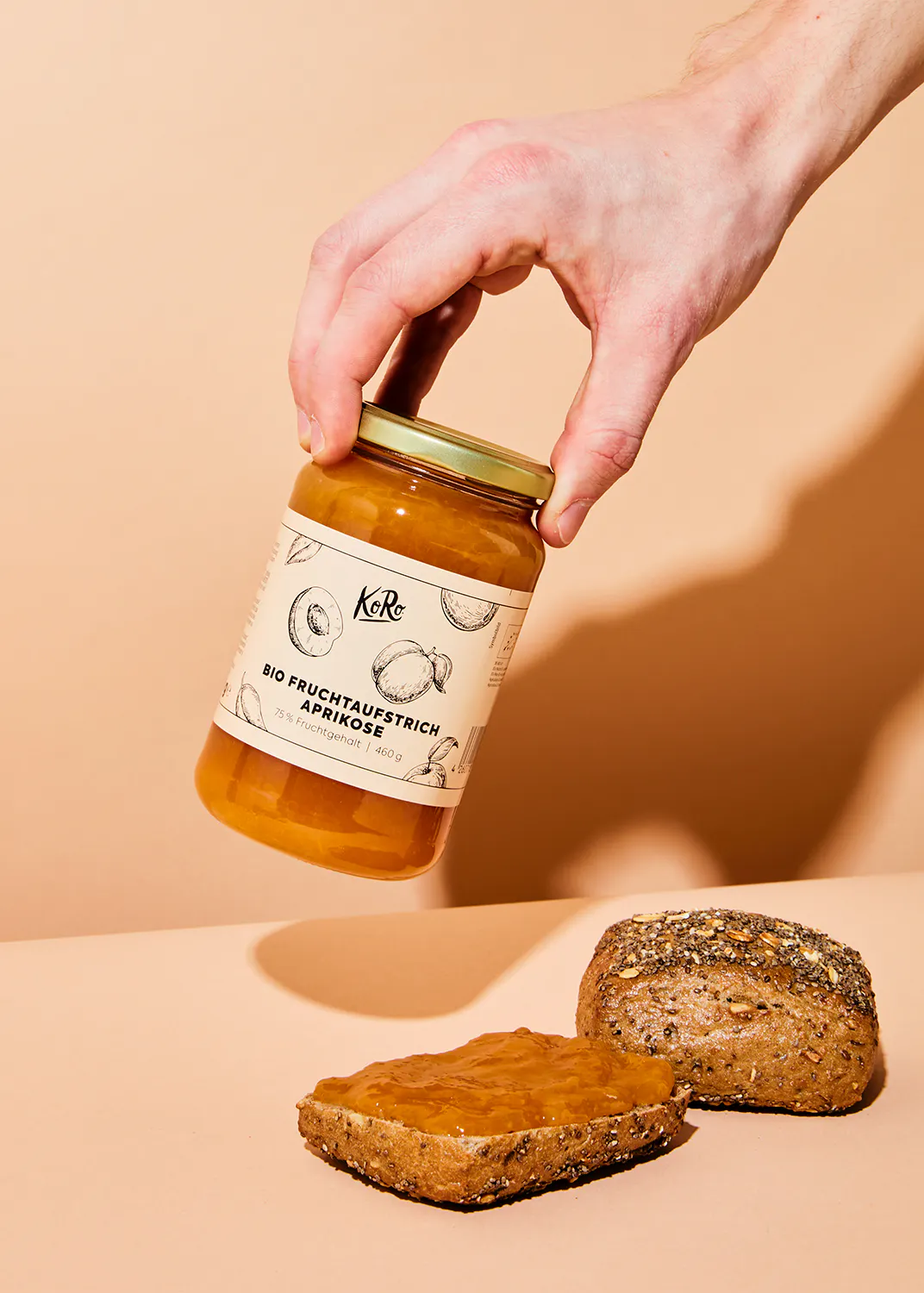 a person is holding a jar of bio fruchtaufstrich aprikosen
