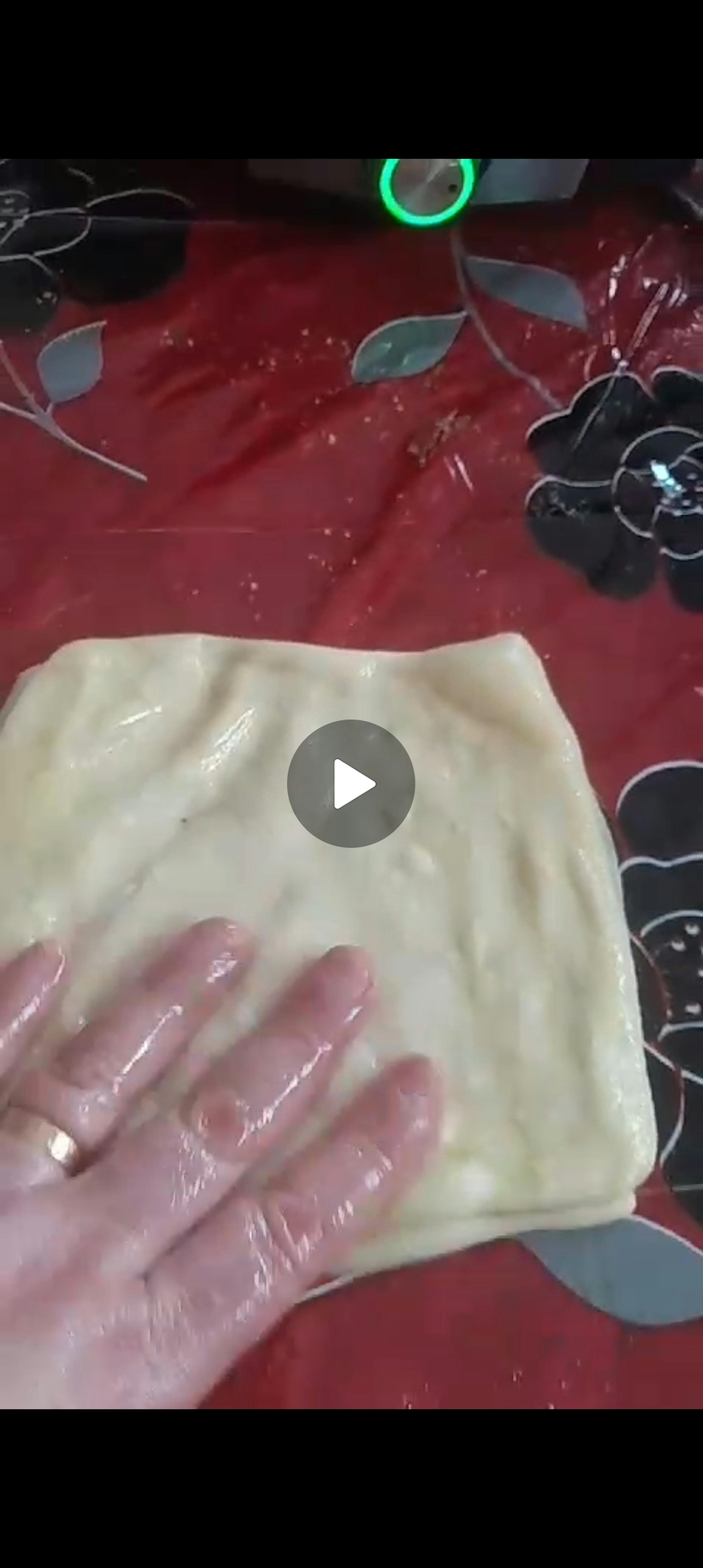 una persona tiene in mano un pezzo di pasta su un tavolo rosso