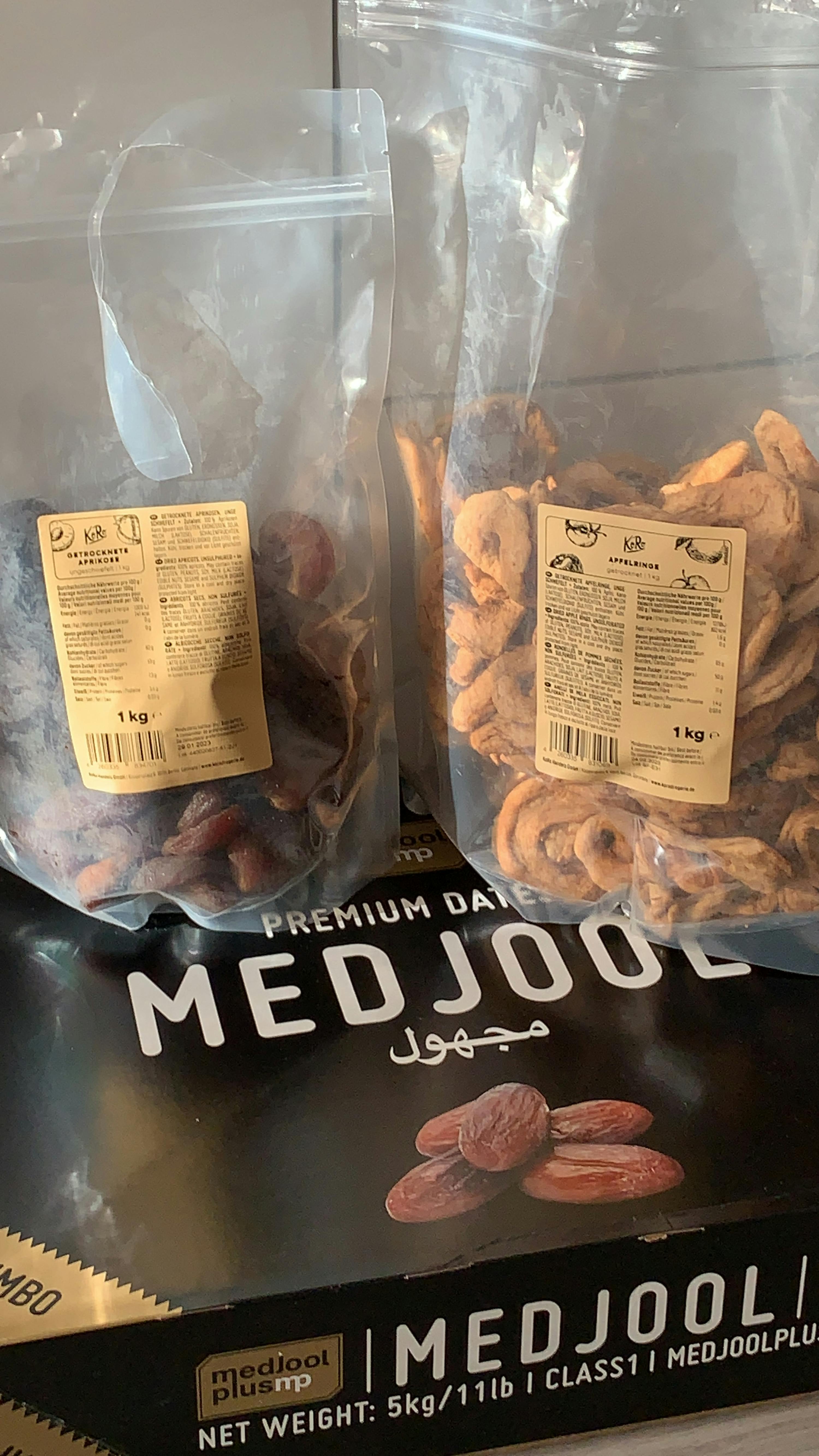 two bags of medjool premium dates next to a box of medjool