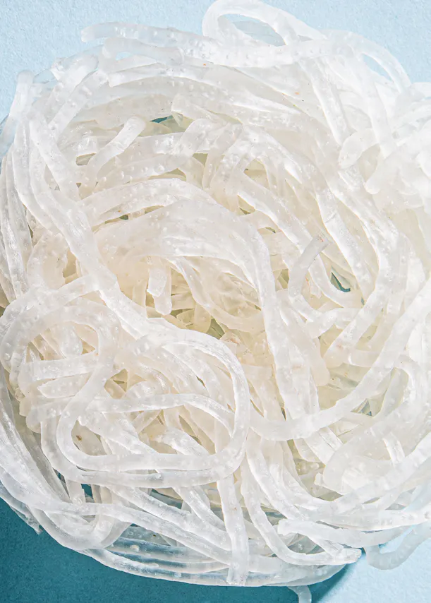 ein Haufen weißer Nudeln liegt auf einem blauen Tisch