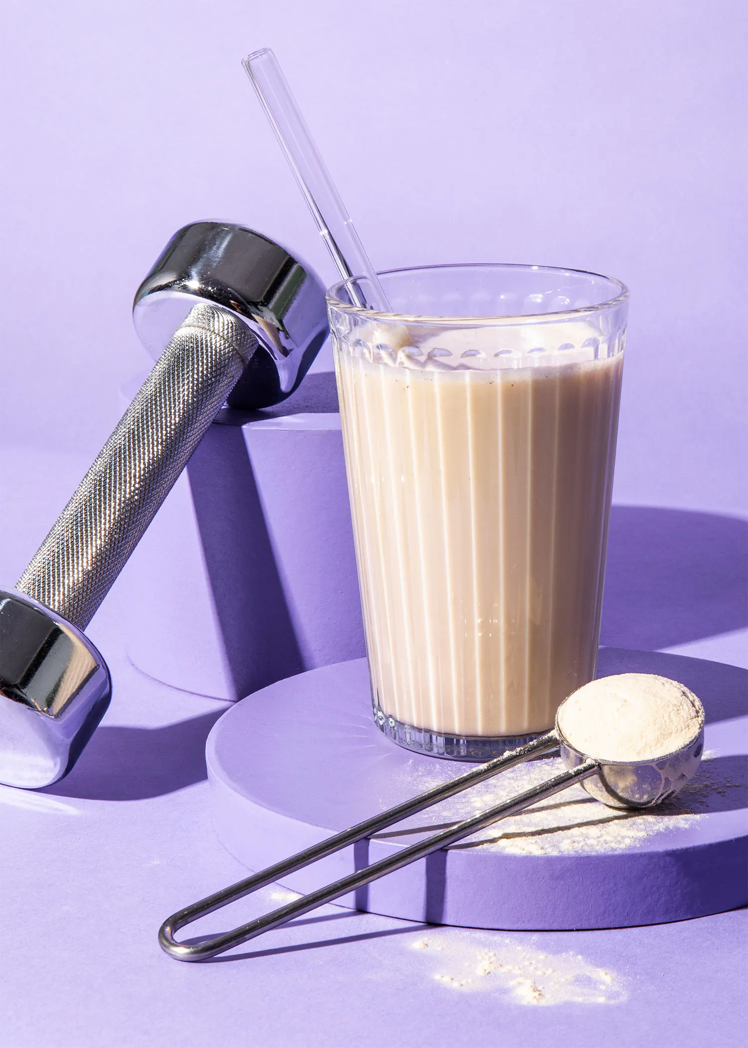 un verre de boisson à côté d' un haltère et d' une cuillère