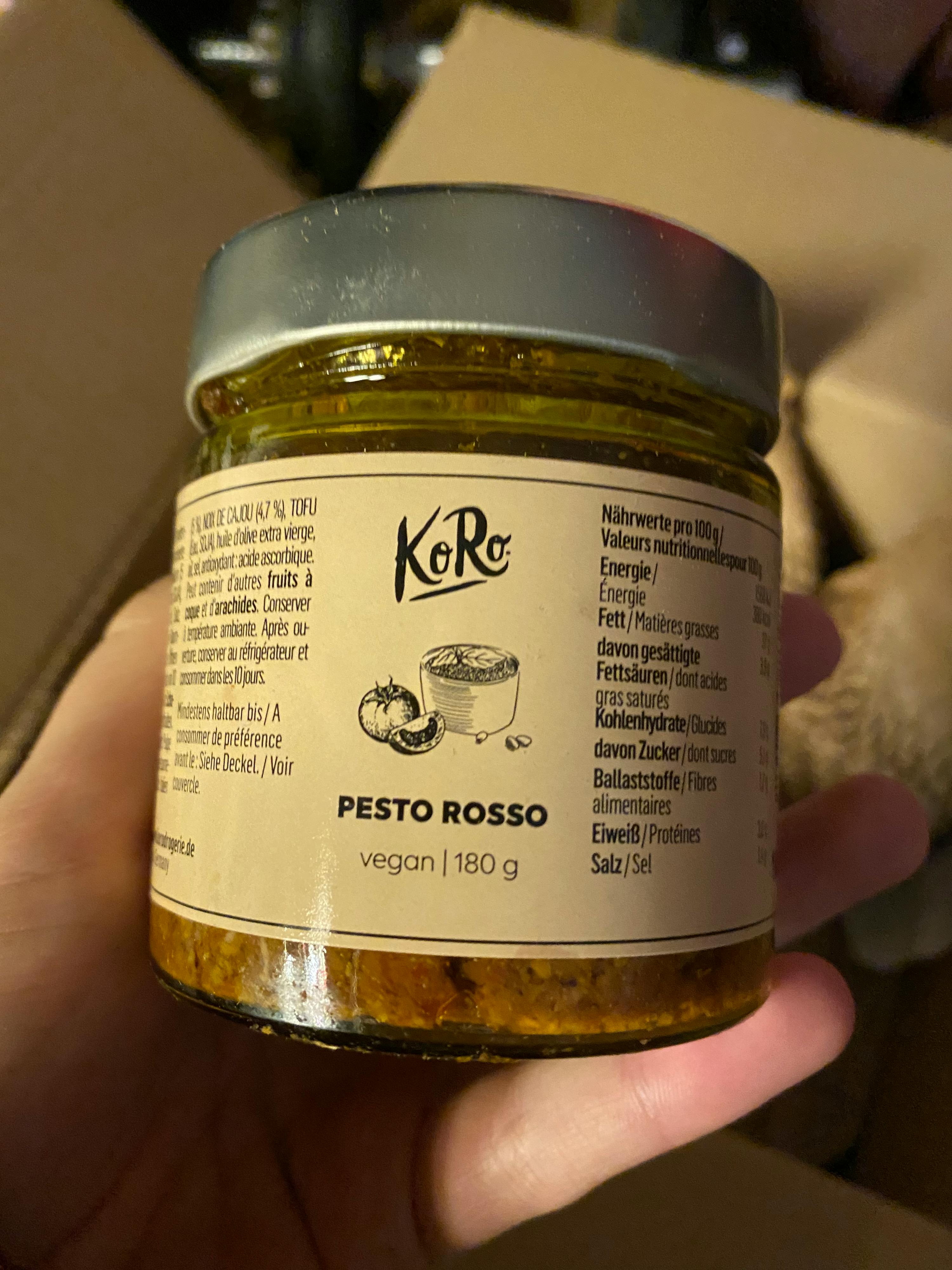 una persona tiene in mano un barattolo di pesto rosso vegan