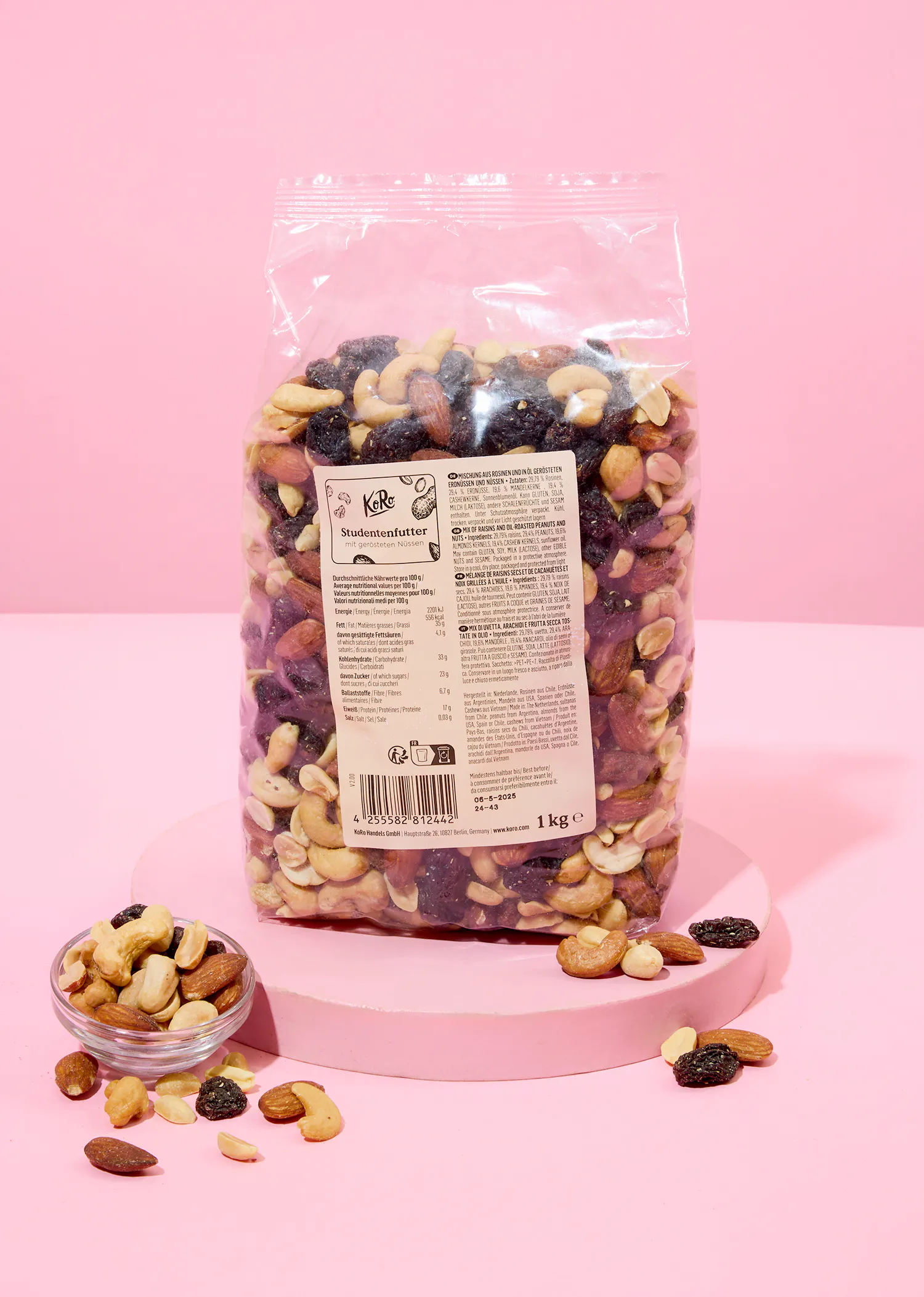 eine Tüte gemischte Nüsse auf einem rosa Tisch