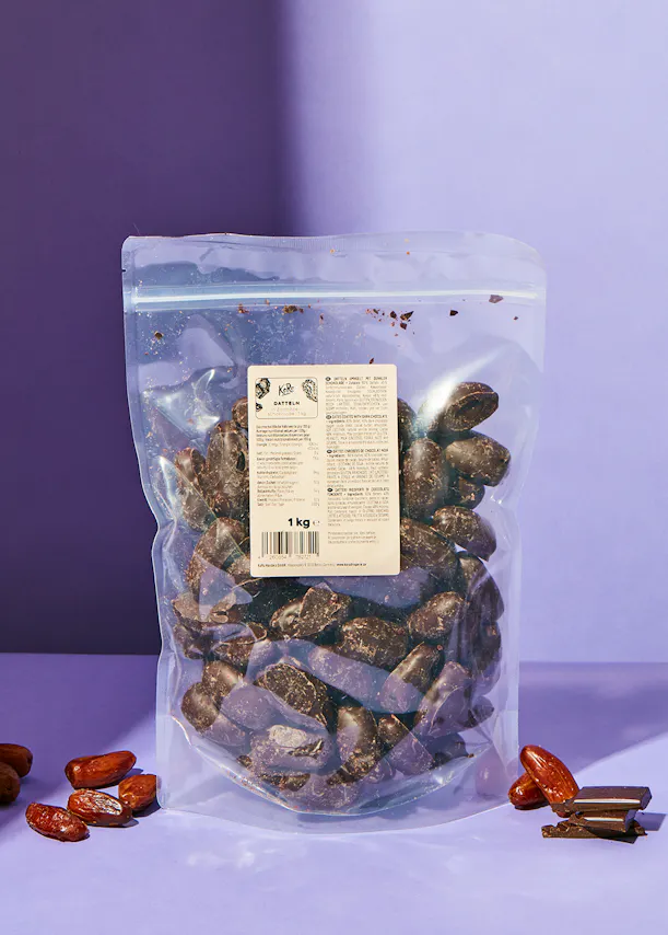 a bag of chocolate covered dates on a purple table