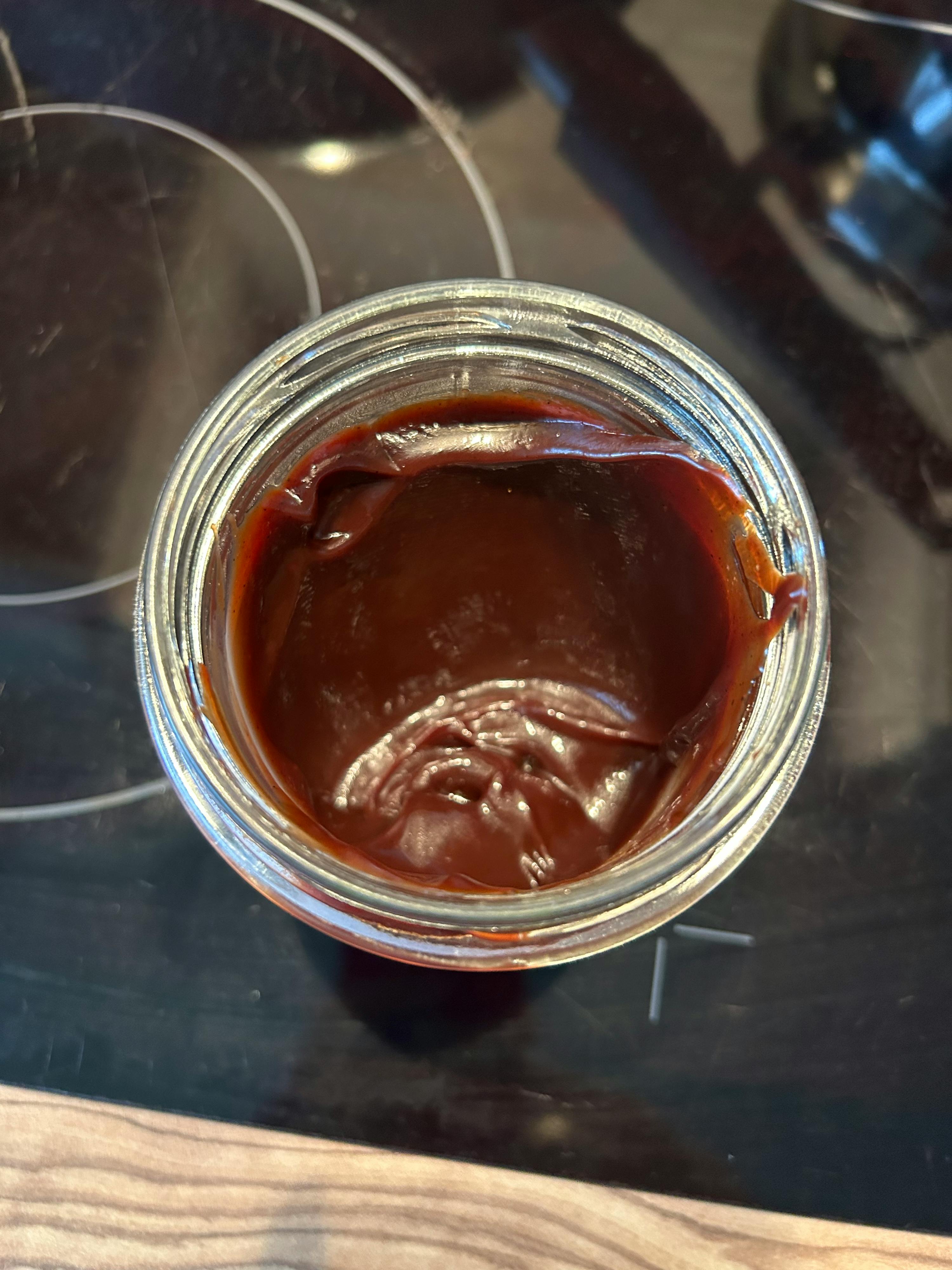 a jar of chocolate sauce on a stove top