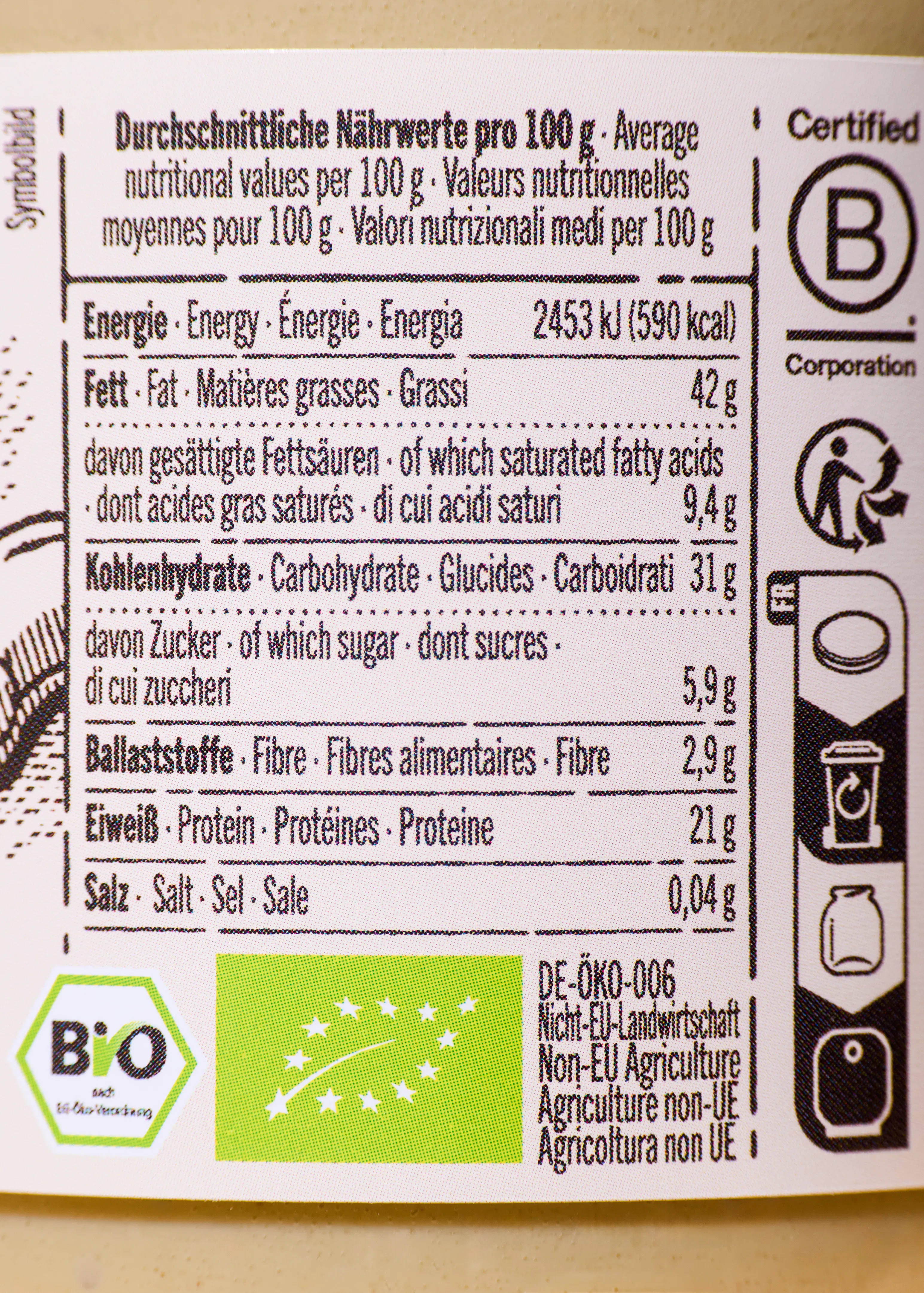 ein bild zeigt eine nährwerttabelle pro 100g mit angaben zu energie, fett, kohlenhydraten, ballaststoffen, eiweiß und salz, ergänzt durch bio-zertifizierungen und recycling-symbole.
