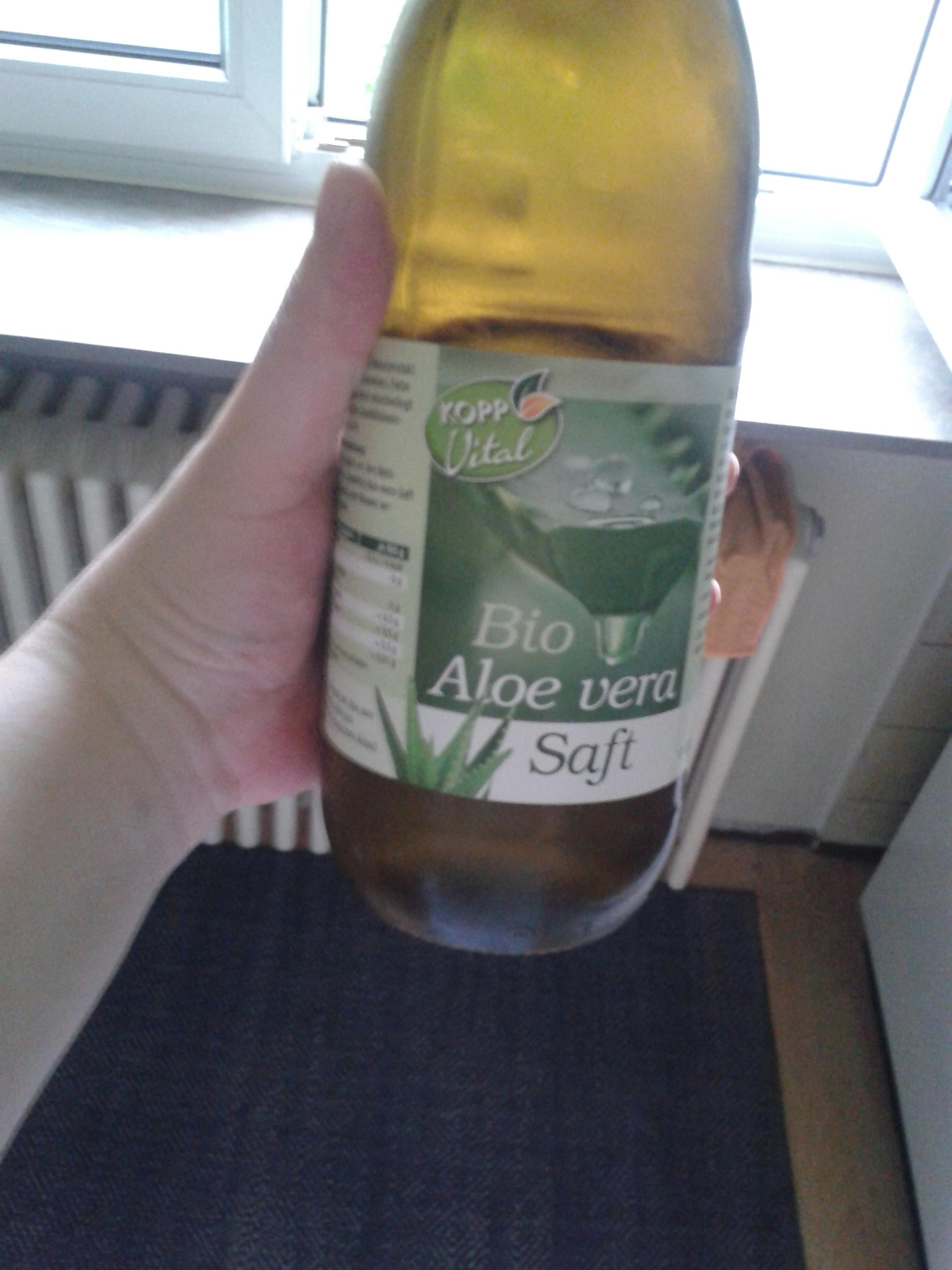 a person is holding a bottle of bio aloe vera 7 soft