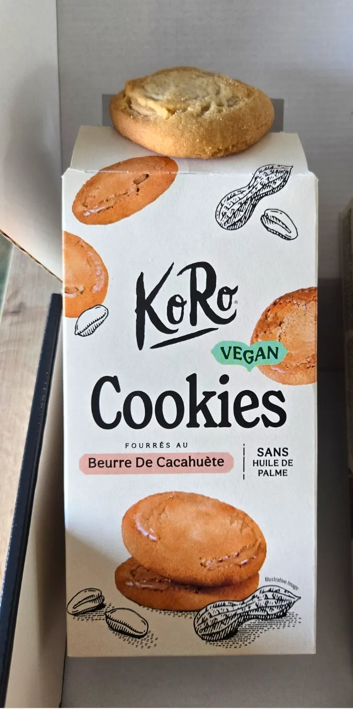 confezione di biscotti vegani koro al burro di arachidi senza olio di palma con un biscotto reale appoggiato sopra.