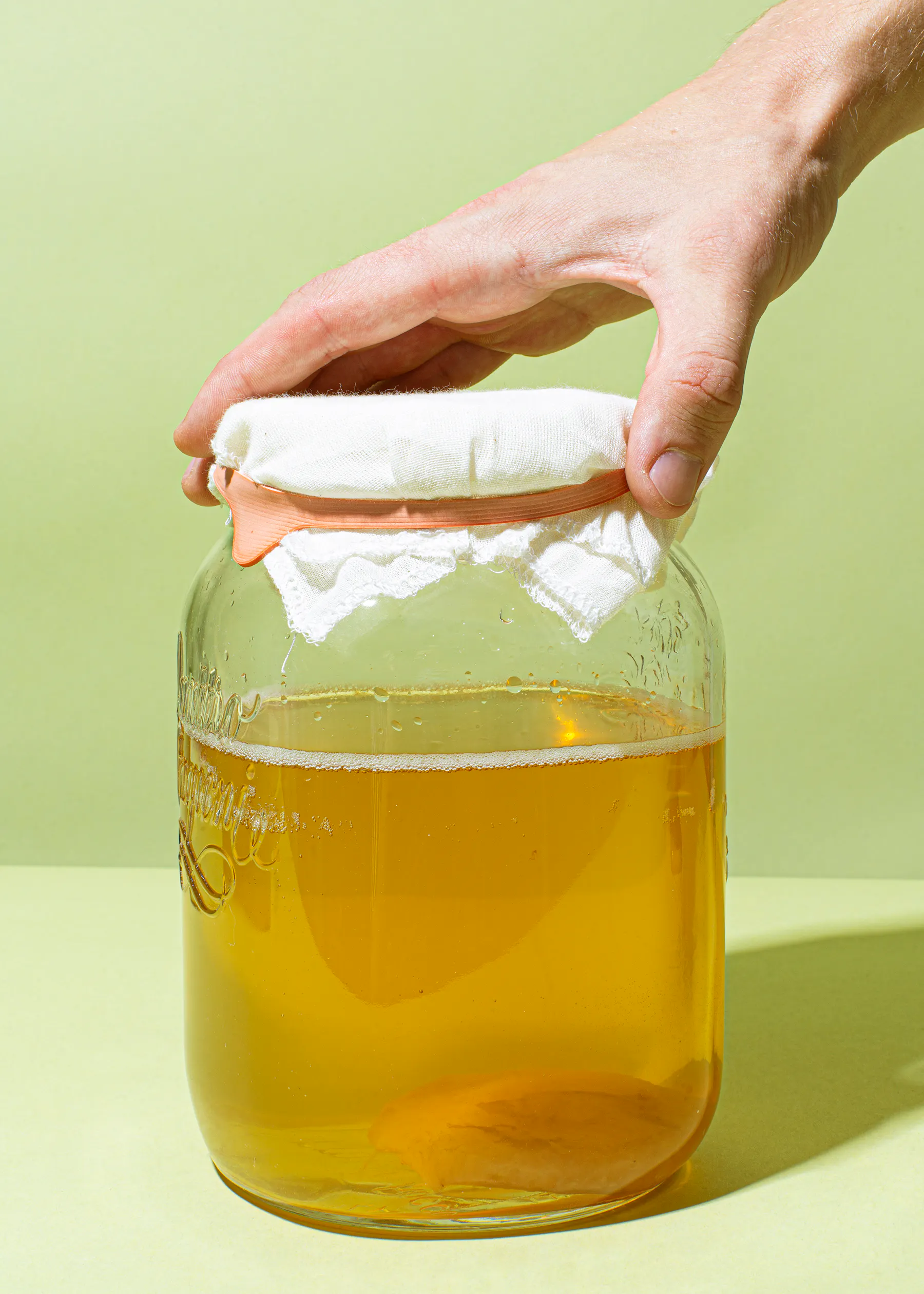 eine Person hält ein Glas mit einem weißen Tuch auf der Decke