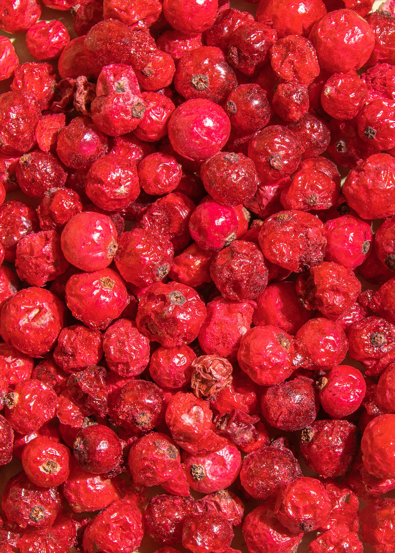 a pile of red berries with a few missing