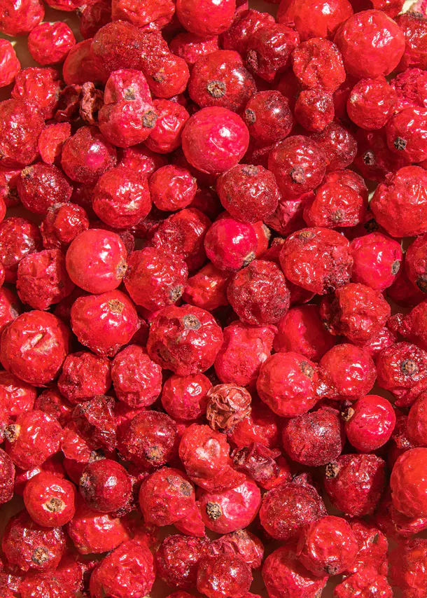 a pile of red berries with a few missing