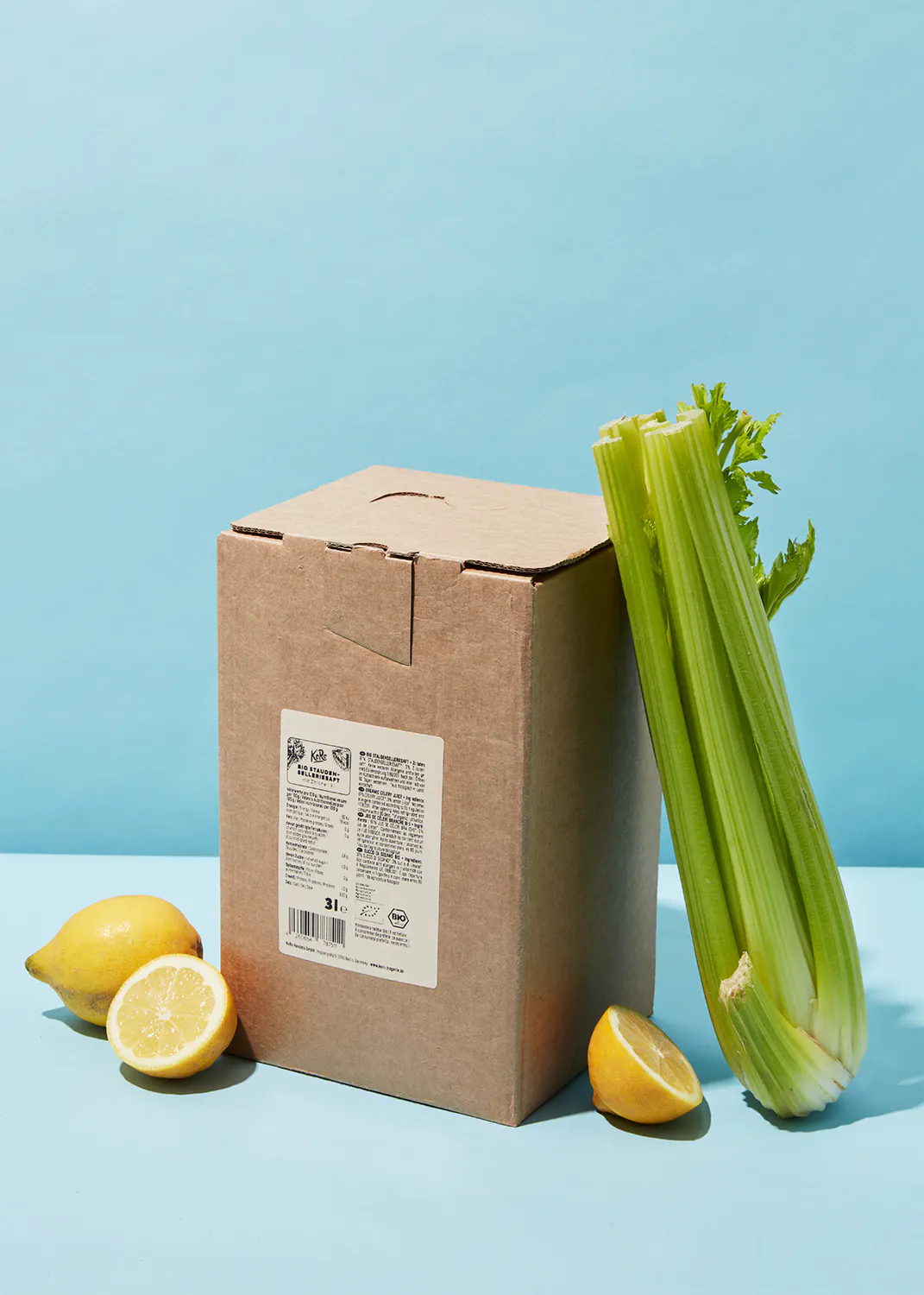 una caja de cebolla y limones sobre una mesa azul