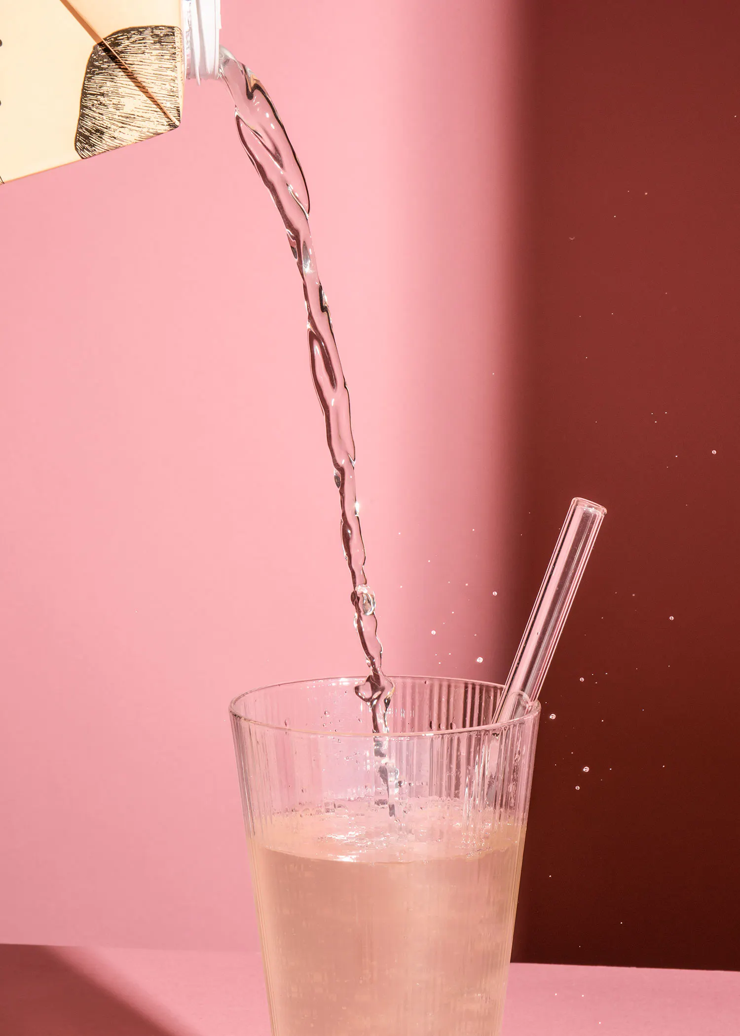 a straw is being poured into a glass of liquid
