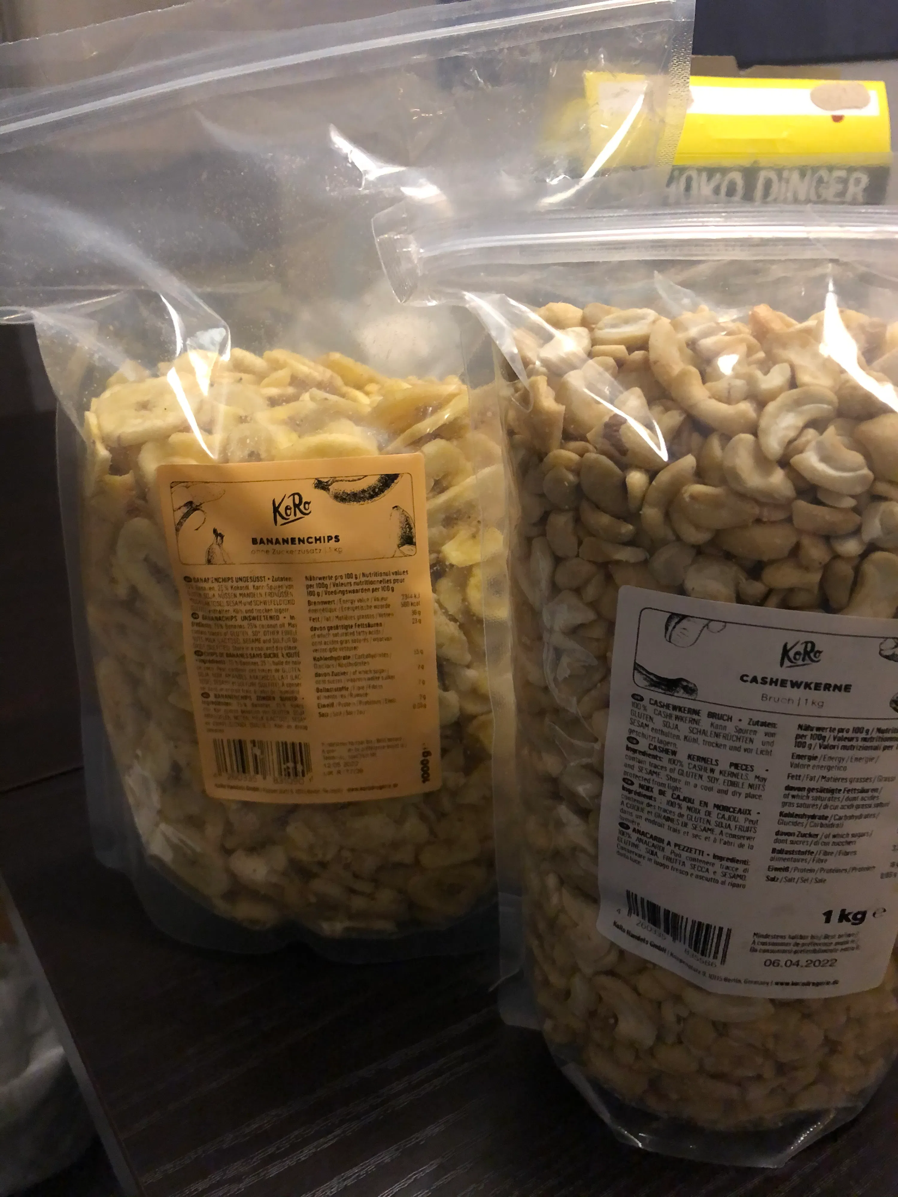 zwei Plastiktüten mit Cashewkernen liegen nebeneinander
